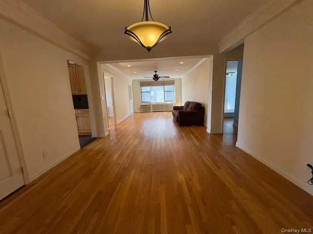 Unfurnished dining area with light wood-style floors, ornamental molding, and a ceiling fan Unfurnished dining area with light wood-style floors, ornamental molding, and a ceiling fan