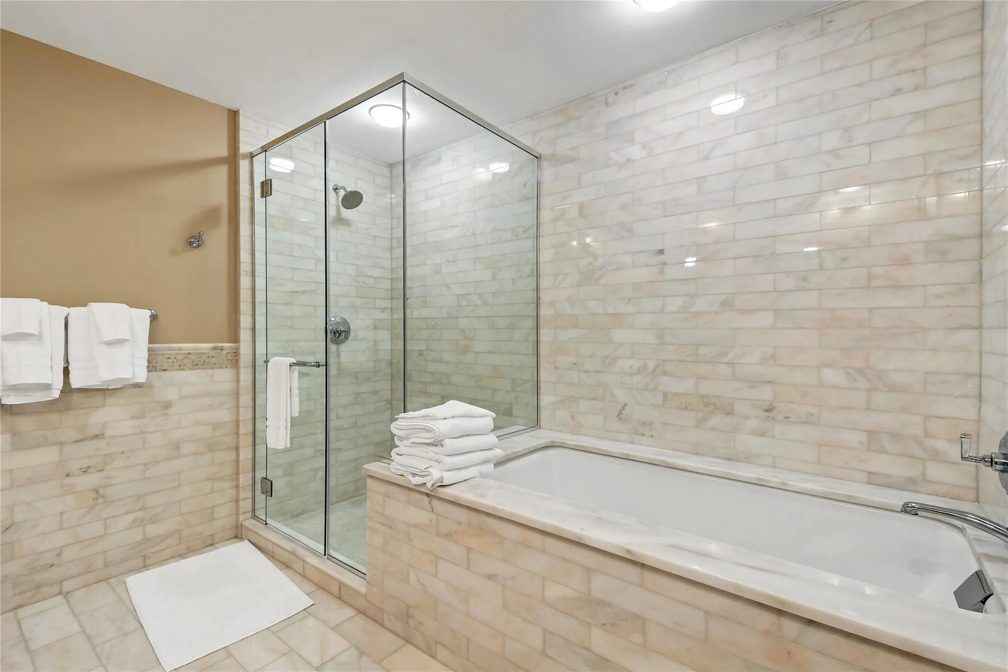 Full bathroom with a stall shower, tile patterned flooring, a garden tub, and tile walls Full bathroom with a stall shower, tile patterned flooring, a garden tub, and tile walls