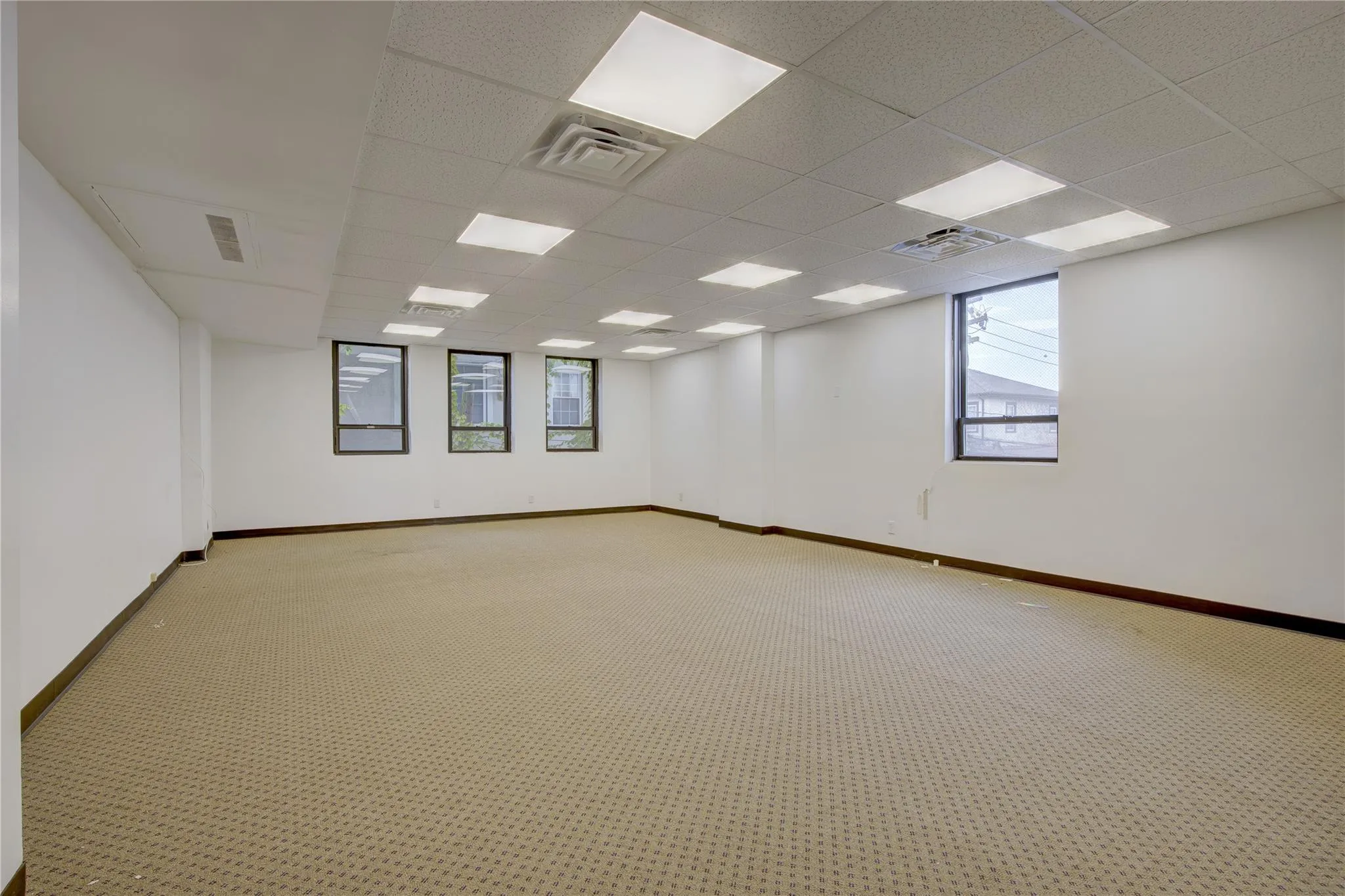Unfurnished room featuring light colored carpet, baseboards, and a paneled ceiling Unfurnished room featuring light colored carpet, baseboards, and a paneled ceiling