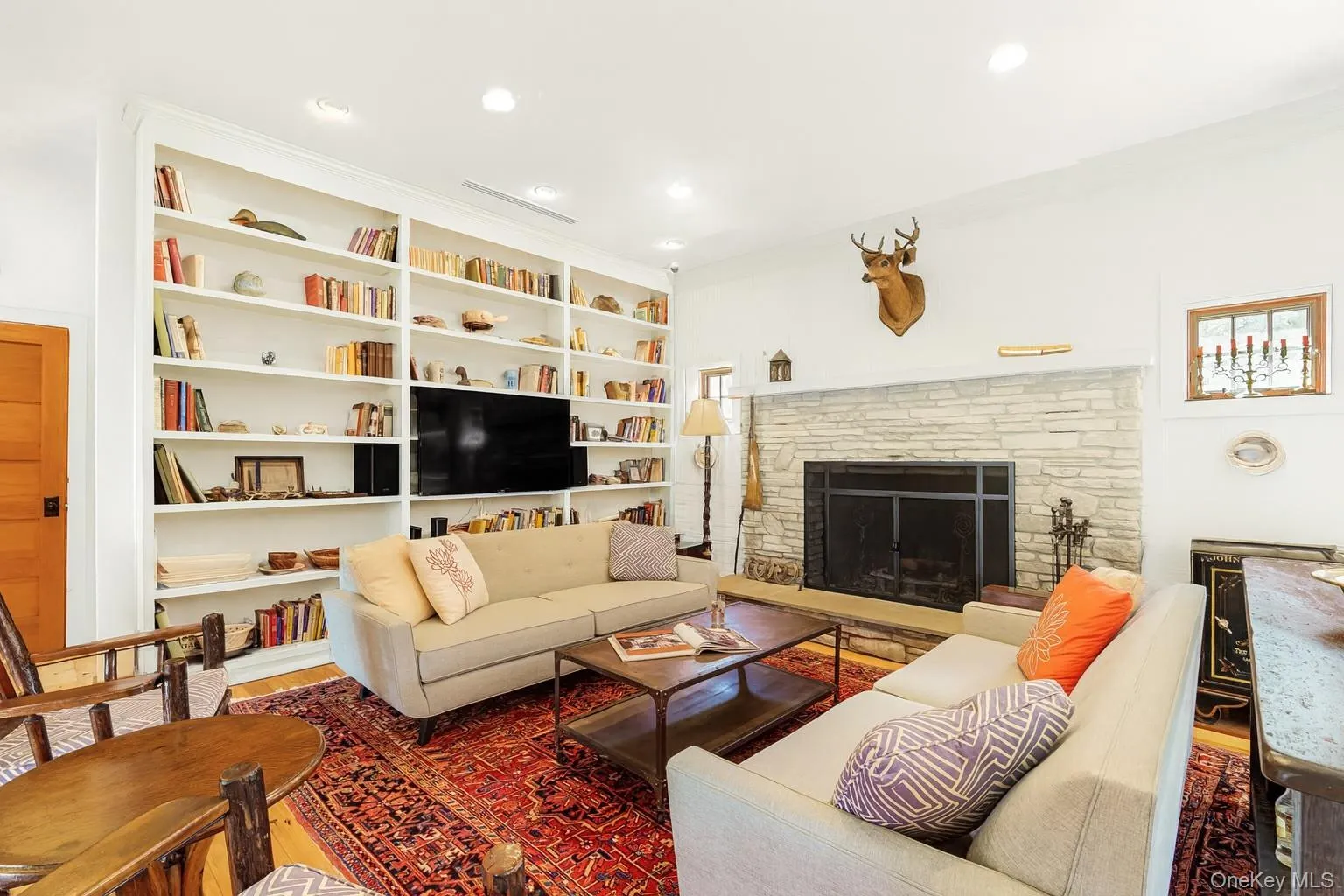 Living area with a fireplace, wood finished floors, and recessed lighting Living area with a fireplace, wood finished floors, and recessed lighting