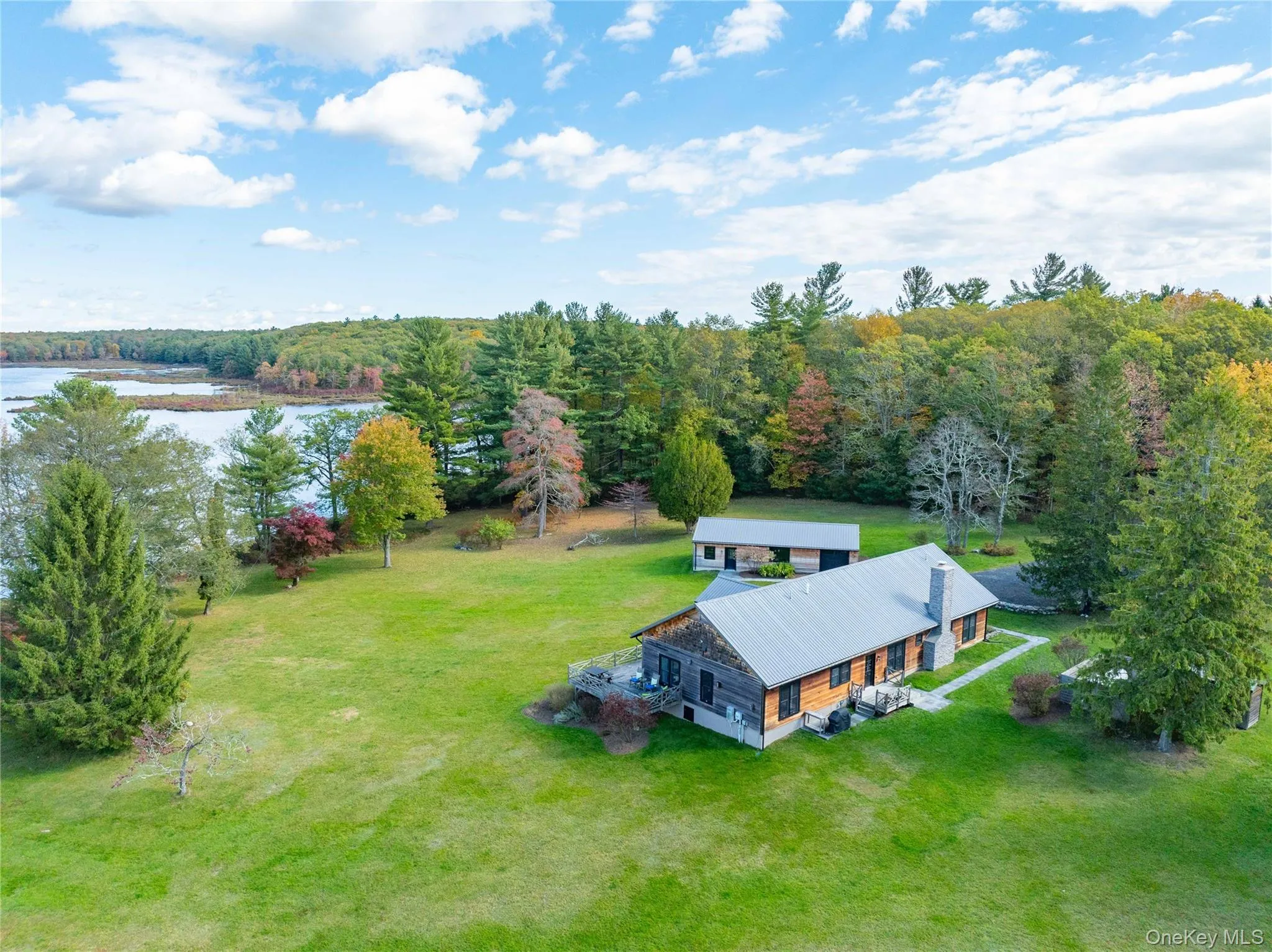 View of subject property featuring a large body of water and a heavily wooded area View of subject property featuring a large body of water and a heavily wooded area