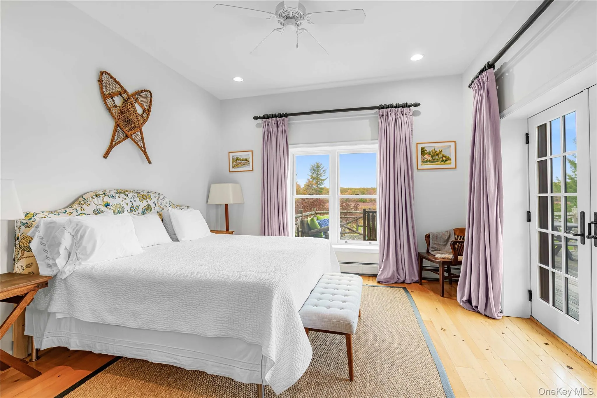 Bedroom featuring multiple windows, light wood-style floors, recessed lighting, ceiling fan, and a baseboard heating unit Bedroom featuring multiple windows, light wood-style floors, recessed lighting, ceiling fan, and a baseboard heating unit