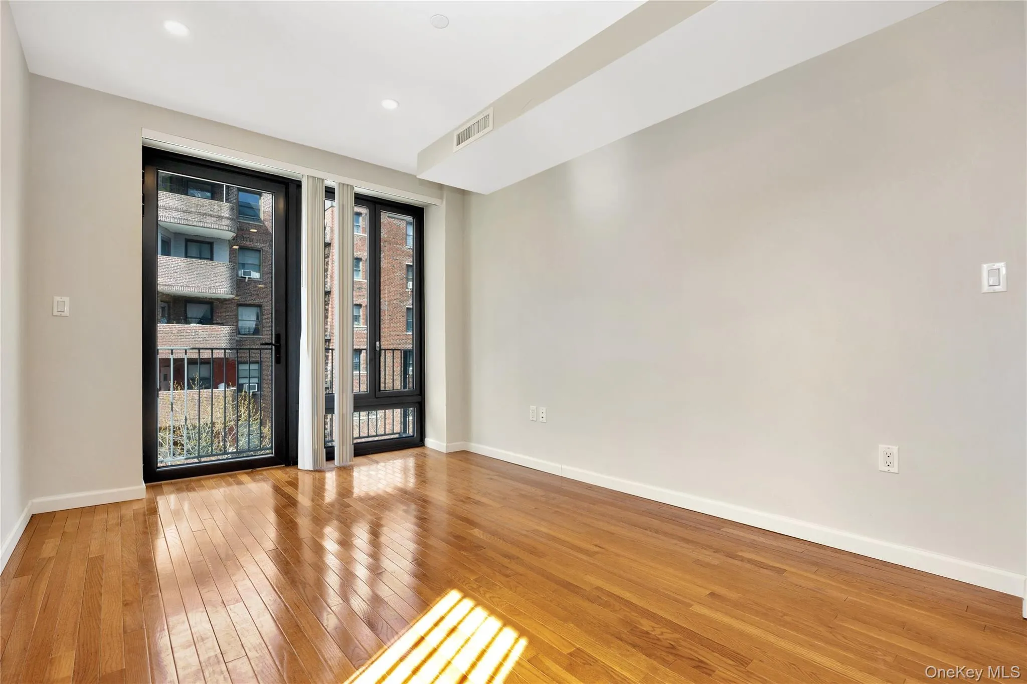 Empty room featuring visible vents, baseboards, recessed lighting, and hardwood / wood-style flooring Empty room featuring visible vents, baseboards, recessed lighting, and hardwood / wood-style flooring
