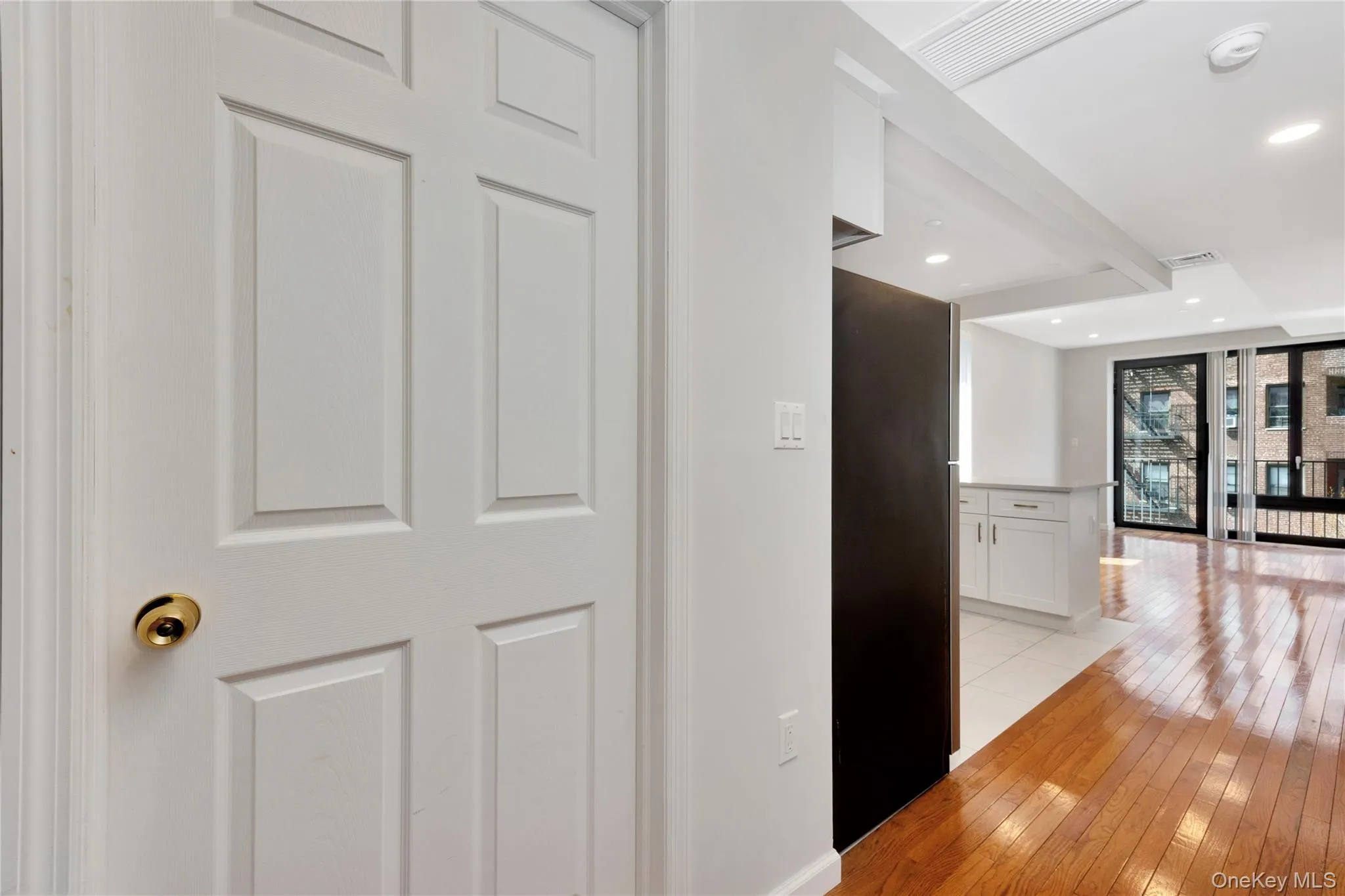 Hallway featuring light wood-style flooring, visible vents, and recessed lighting Hallway featuring light wood-style flooring, visible vents, and recessed lighting