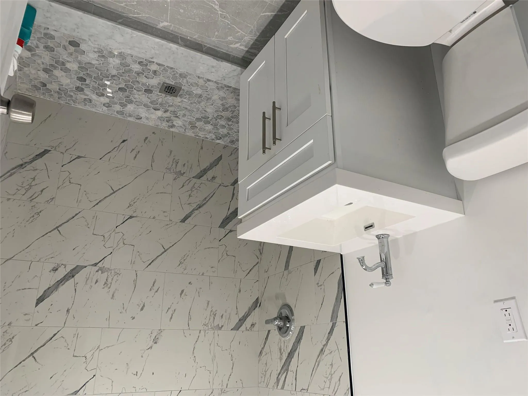 Bathroom featuring toilet, a stall shower, vanity, and marble finish flooring Bathroom featuring toilet, a stall shower, vanity, and marble finish flooring