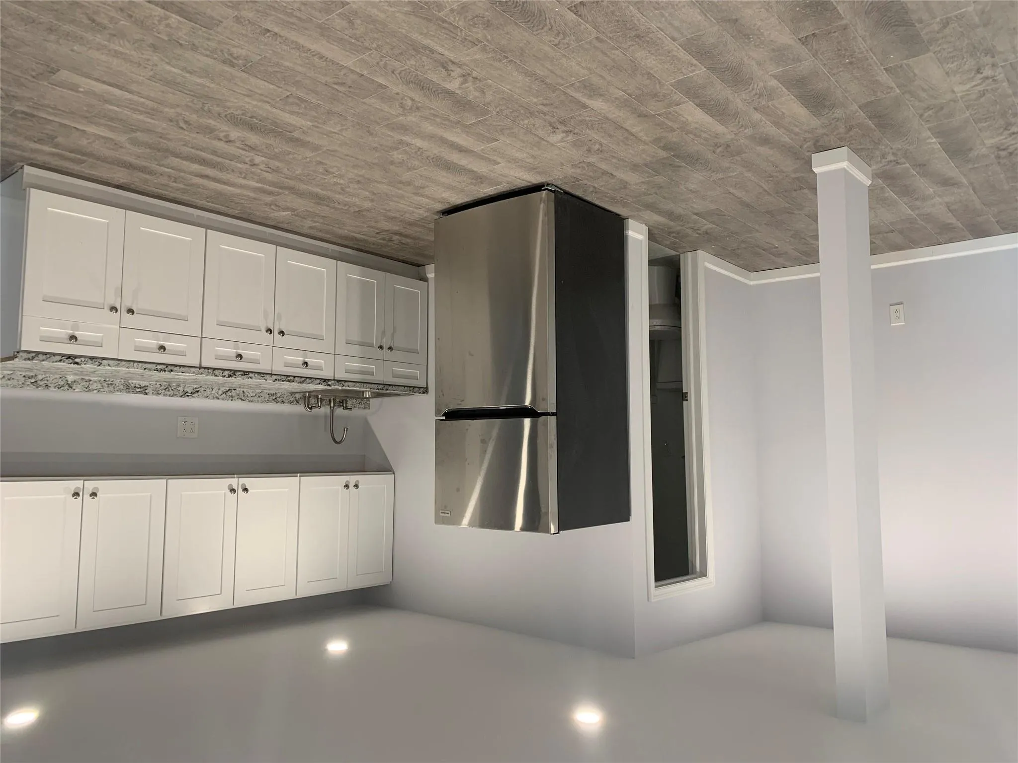 Kitchen with freestanding refrigerator, a sink, recessed lighting, light stone countertops, and light wood finished floors Kitchen with freestanding refrigerator, a sink, recessed lighting, light stone countertops, and light wood finished floors