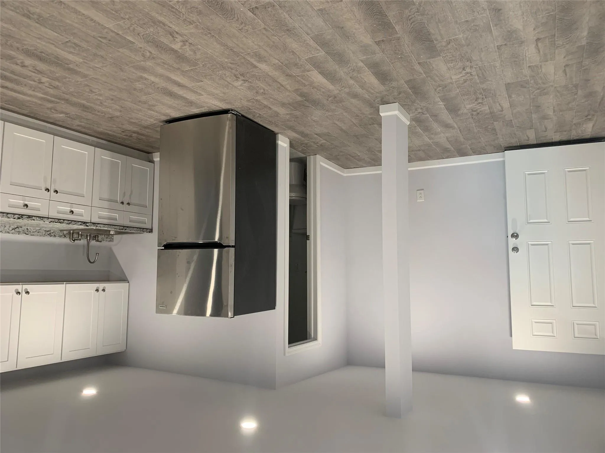 Kitchen with refrigerator, a sink, light stone countertops, recessed lighting, and light wood finished floors Kitchen with refrigerator, a sink, light stone countertops, recessed lighting, and light wood finished floors