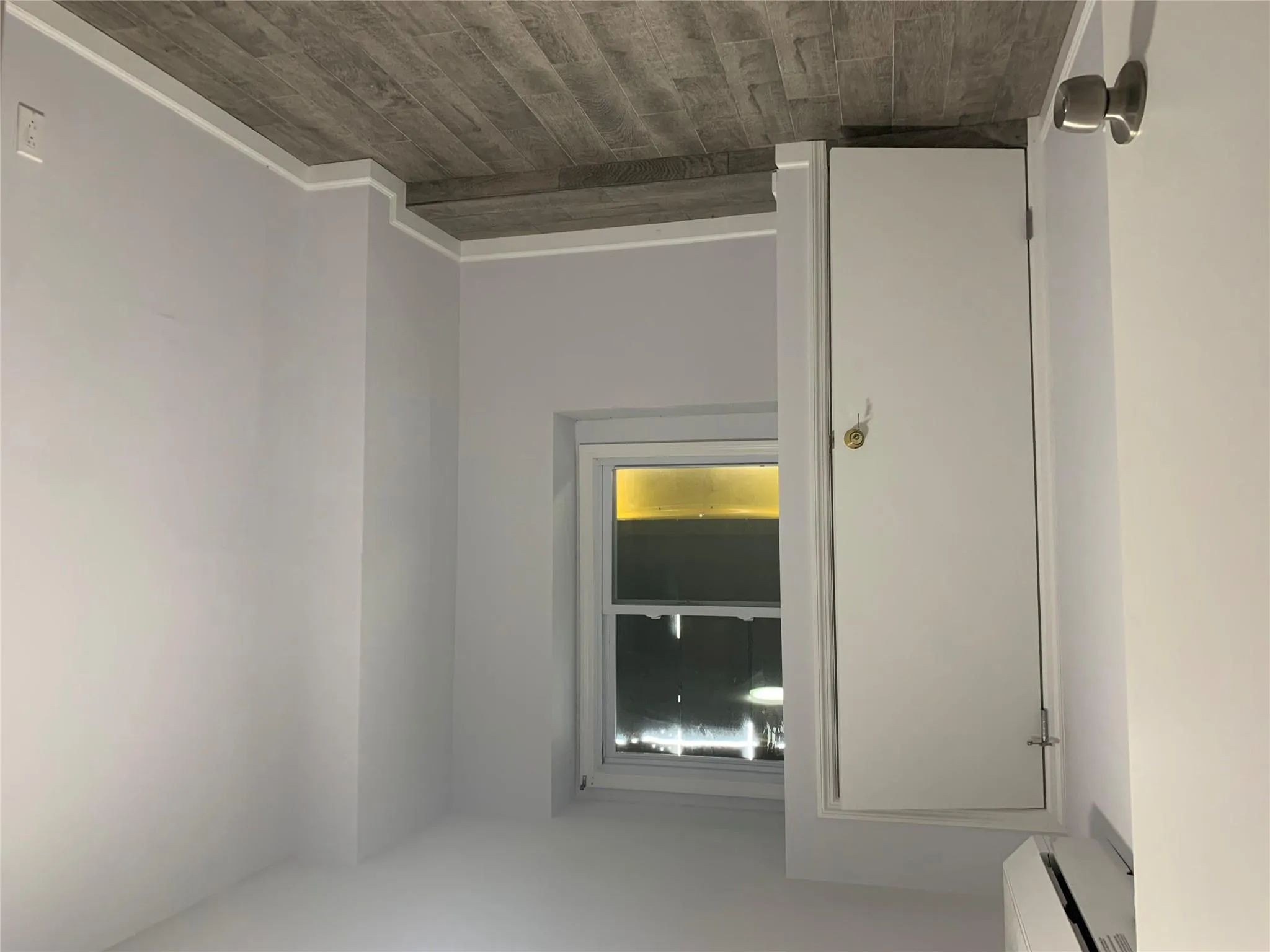 Spare room with dark wood finished floors, baseboards, and an AC wall unit Spare room with dark wood finished floors, baseboards, and an AC wall unit