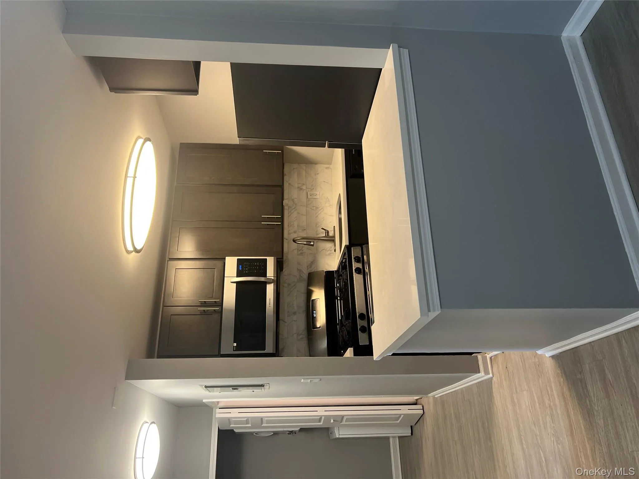 Kitchen featuring stove, fridge, a sink, light countertops, and baseboards Kitchen featuring stove, fridge, a sink, light countertops, and baseboards