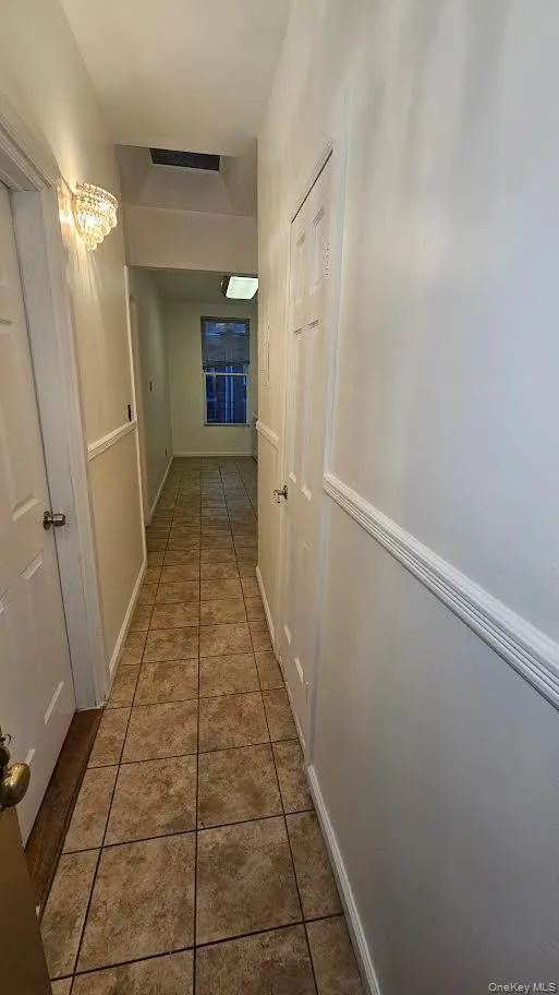 Hallway featuring tile patterned flooring. Hallway featuring tile patterned flooring.
