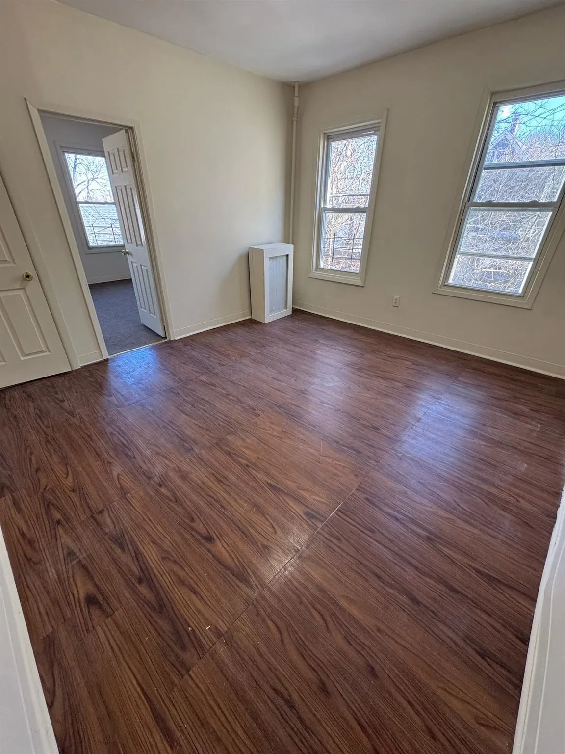 Living room with healthy amount of natural light, baseboards, and dark wood-style flooring Living room with healthy amount of natural light, baseboards, and dark wood-style flooring