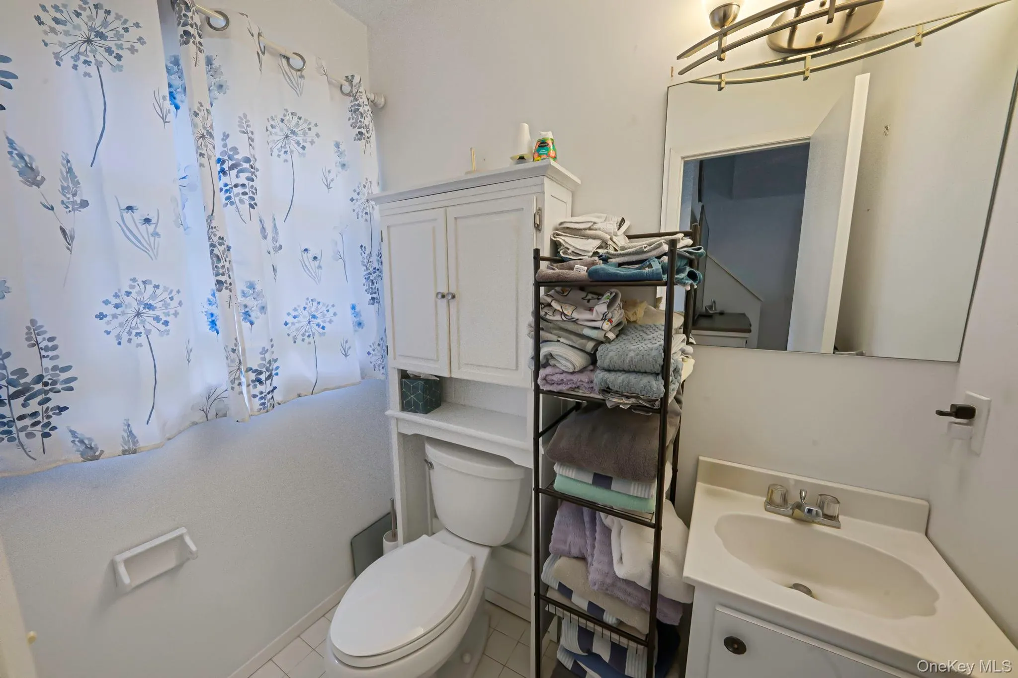 Bathroom featuring toilet, vanity, and tile patterned flooring Bathroom featuring toilet, vanity, and tile patterned flooring
