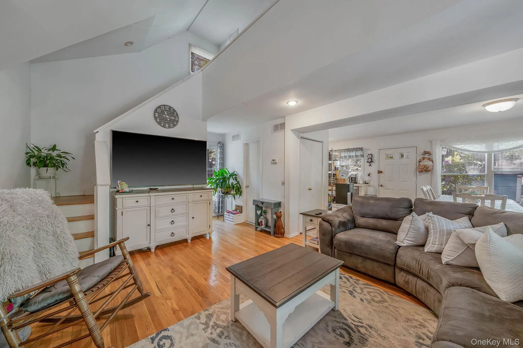 Living area featuring light wood-style flooring and vaulted ceiling Living area featuring light wood-style flooring and vaulted ceiling