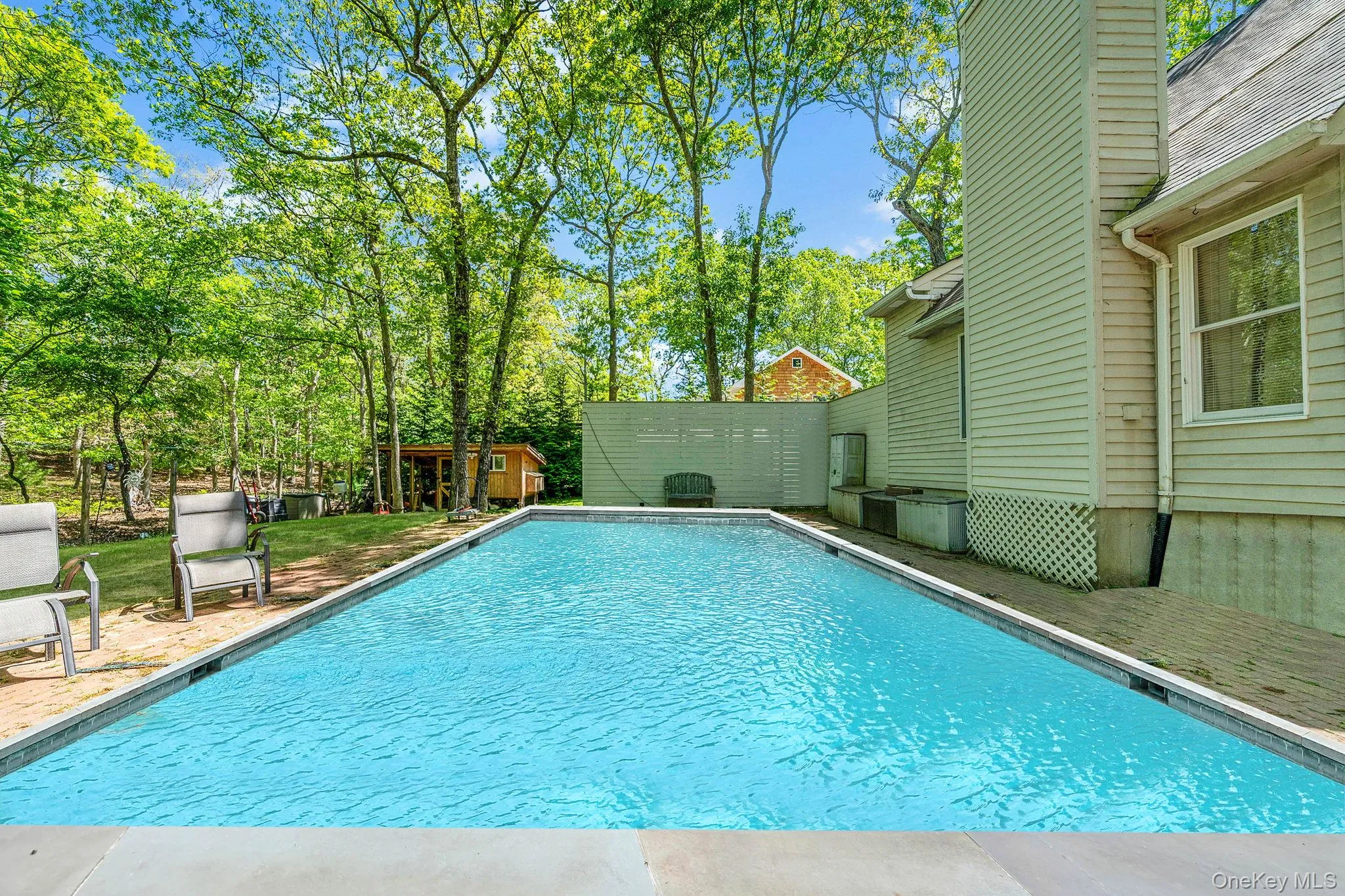 Swimming pool with an outdoor structure and view of scattered trees Swimming pool with an outdoor structure and view of scattered trees