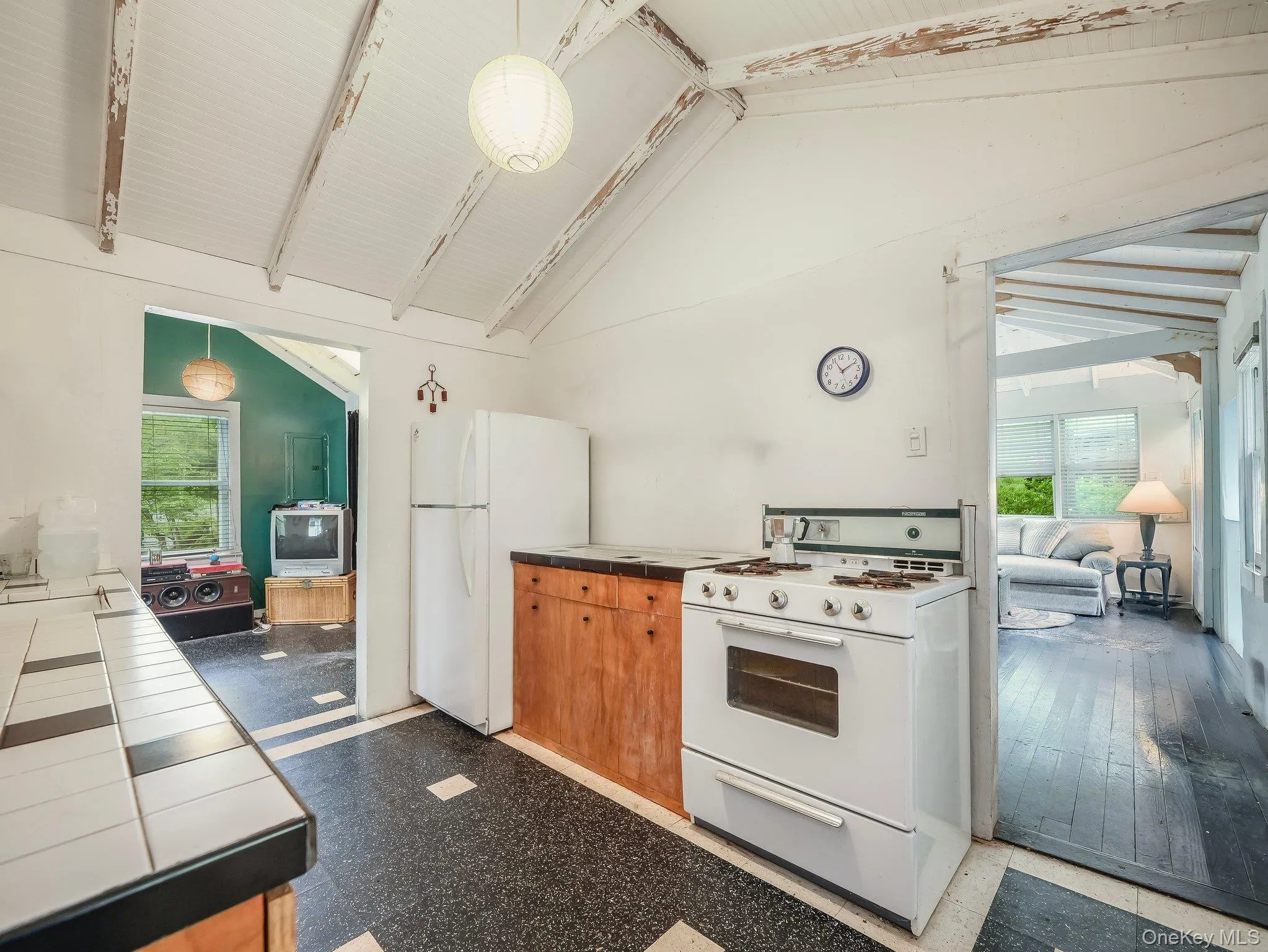 Kitchen featuring white appliances, tile countertops, plenty of natural light, and pendant lighting Kitchen featuring white appliances, tile countertops, plenty of natural light, and pendant lighting