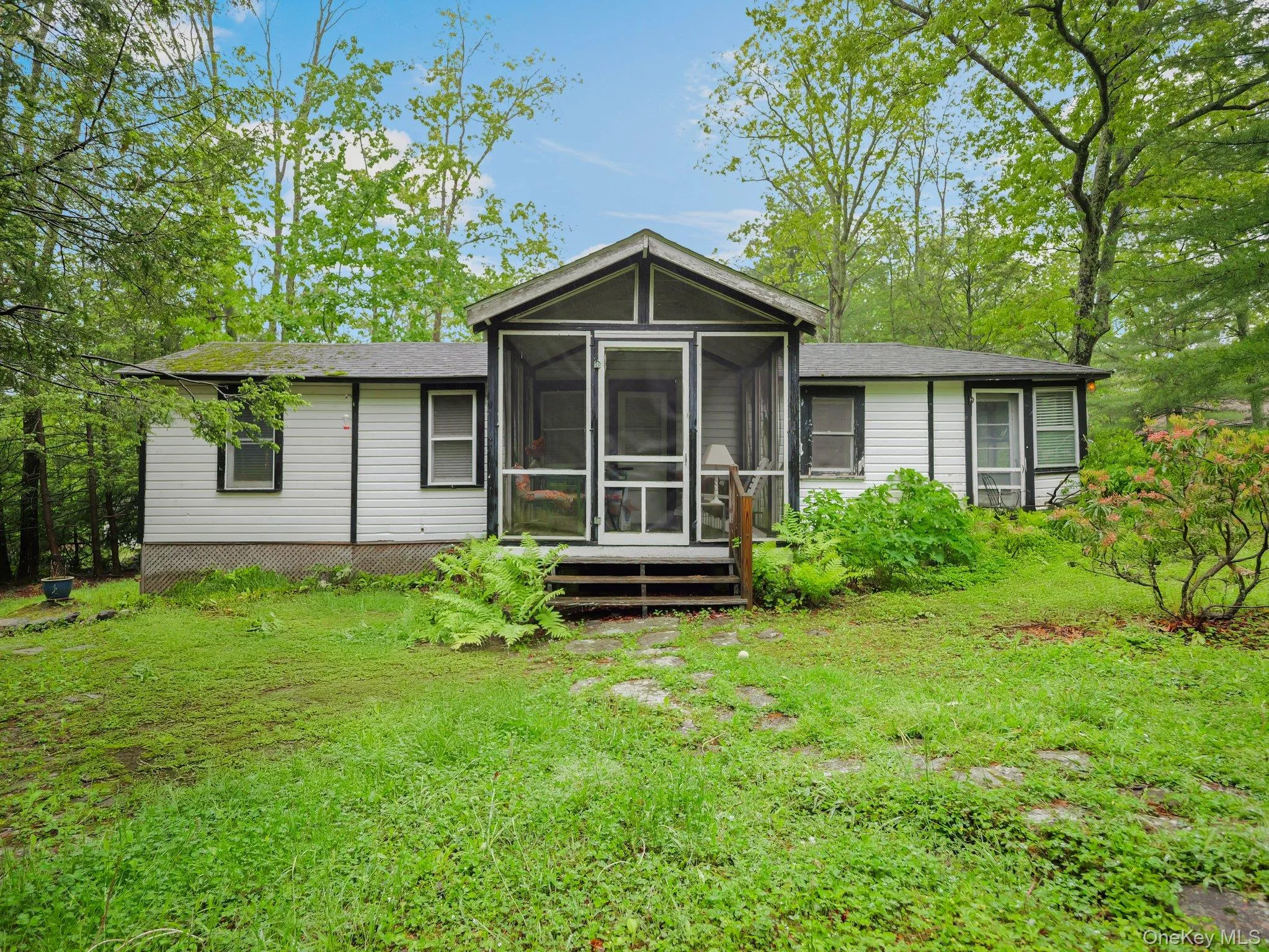 Front of property with a sunroom, a yard, and a shingled roof Front of property with a sunroom, a yard, and a shingled roof