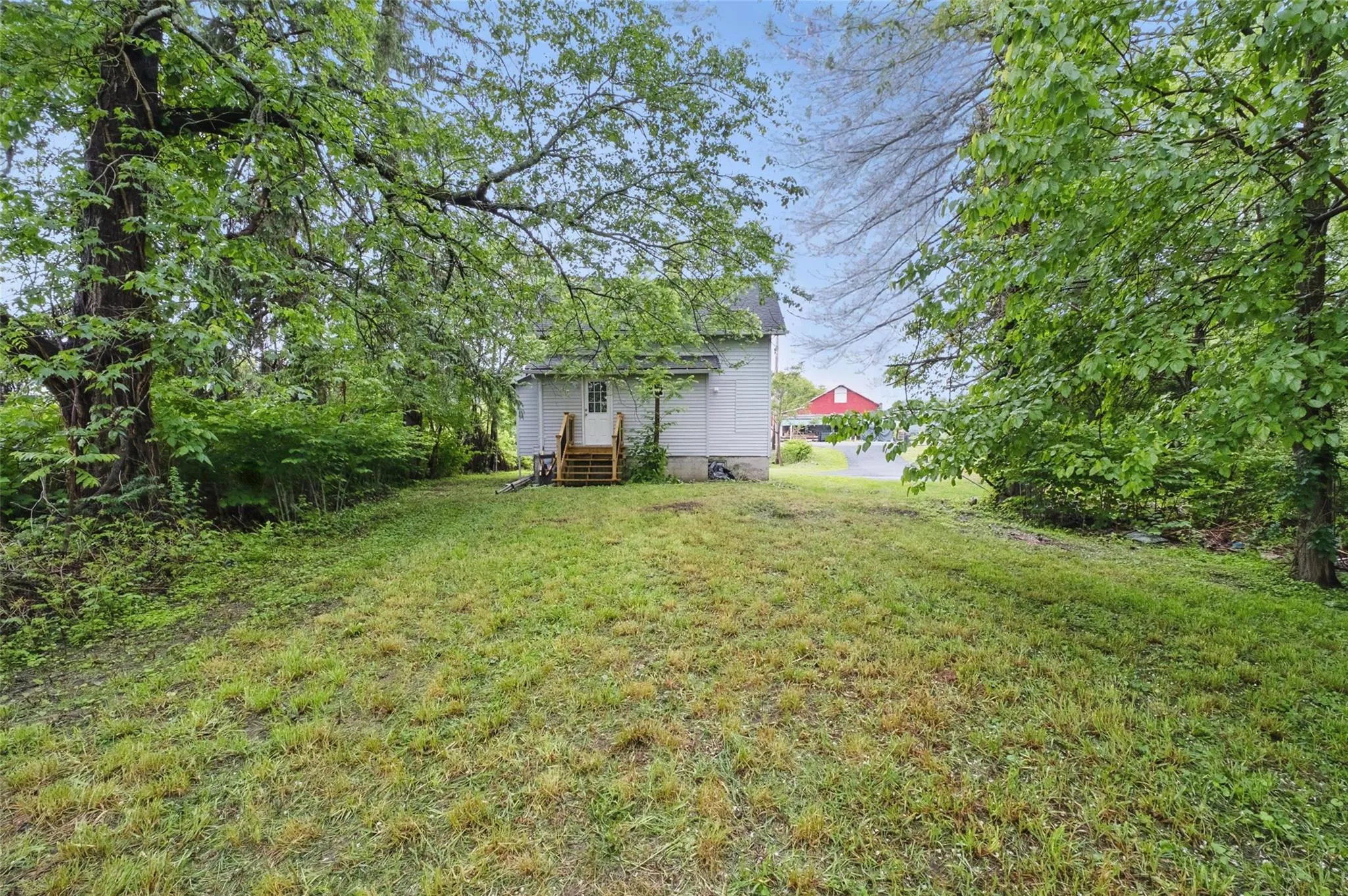 View of green lawn featuring entry steps View of green lawn featuring entry steps