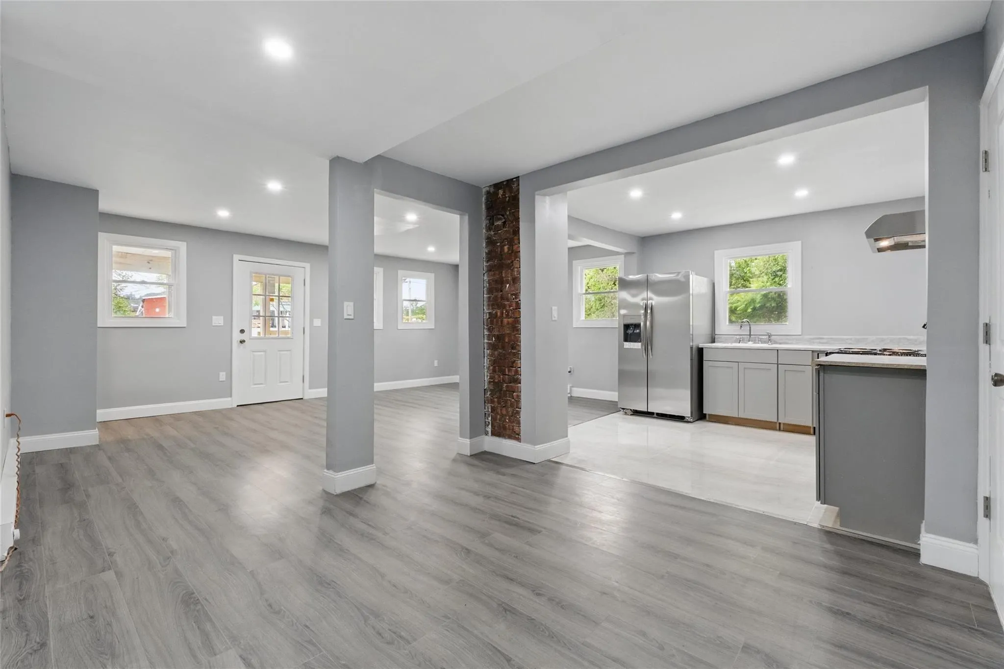 Unfurnished living room featuring recessed lighting, a sink, light wood-style flooring, and baseboards Unfurnished living room featuring recessed lighting, a sink, light wood-style flooring, and baseboards