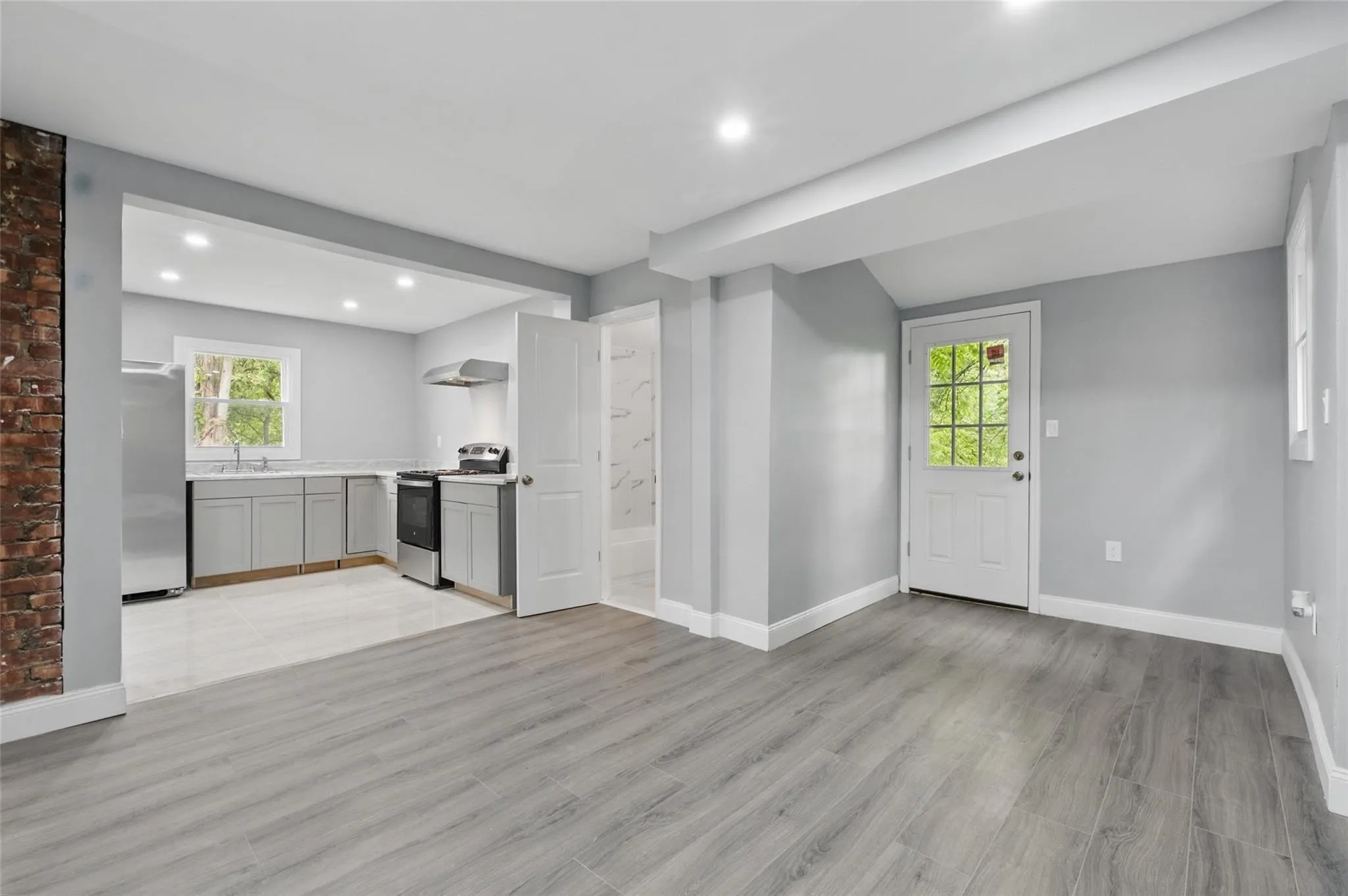 Unfurnished living room with baseboards, light wood-type flooring, recessed lighting, and a sink Unfurnished living room with baseboards, light wood-type flooring, recessed lighting, and a sink