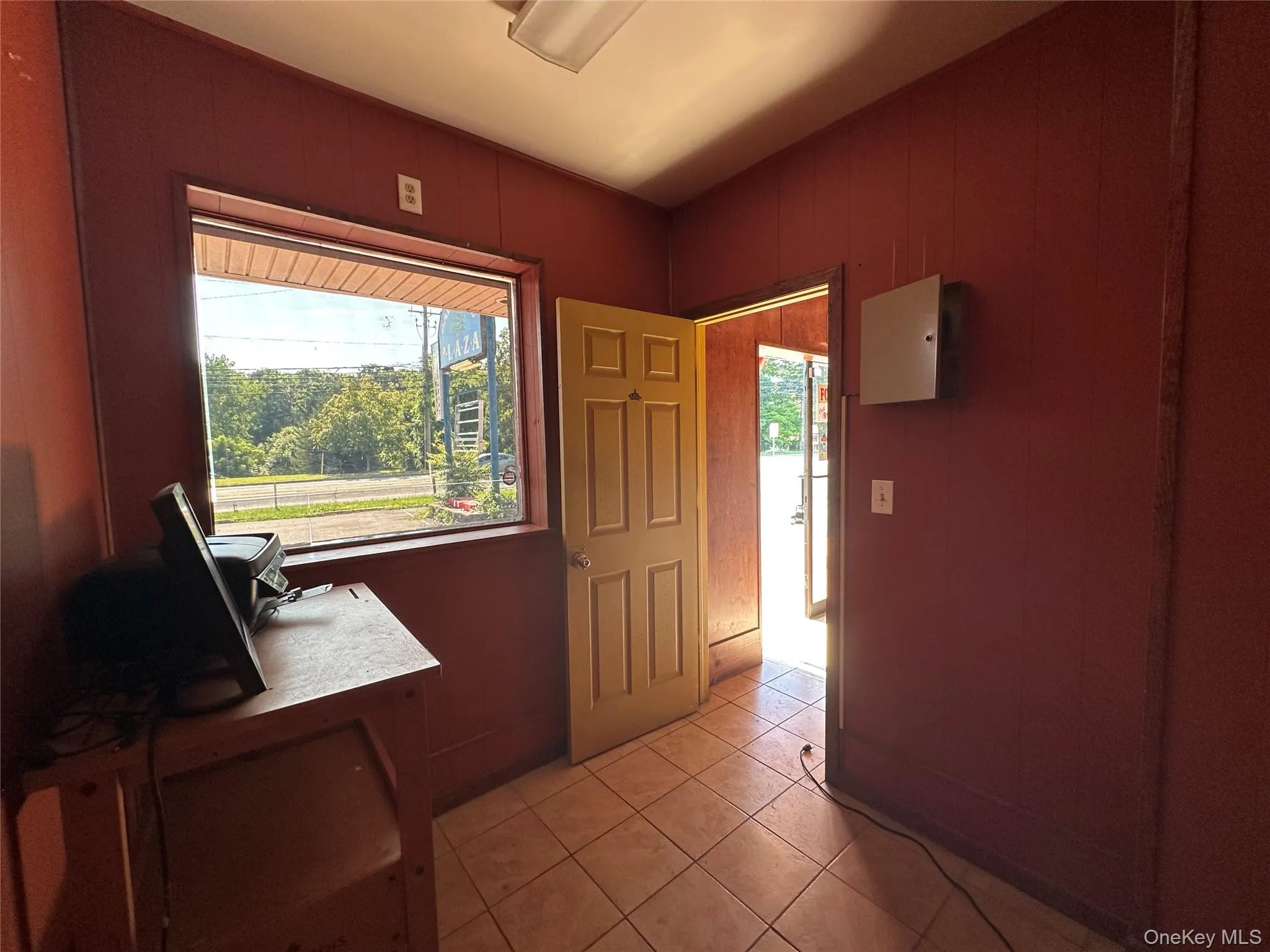 Doorway featuring light tile patterned floors and wooden walls Doorway featuring light tile patterned floors and wooden walls