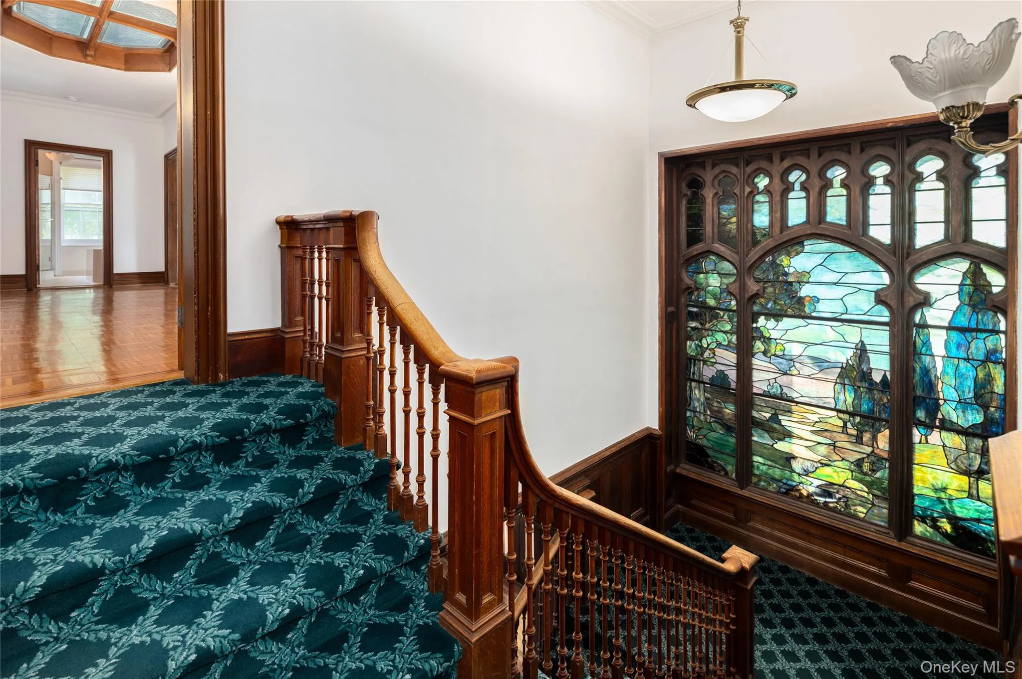 Formal staircase with Tiffany-style stained-glass window. Formal staircase with Tiffany-style stained-glass window.