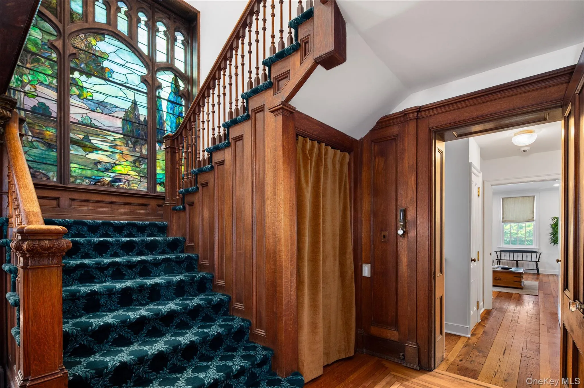 Formal staircase with Tiffany-style stained-glass window. Formal staircase with Tiffany-style stained-glass window.
