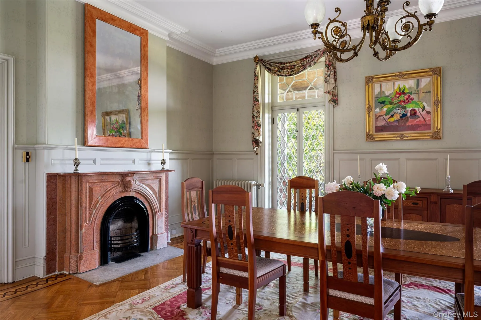 Marble fireplace, diamond-patterned glass doors with veranda access, hand-painted walls, wainscoting, crown molding, gasolier-style chandelier. Marble fireplace, diamond-patterned glass doors with veranda access, hand-painted walls, wainscoting, crown molding, gasolier-style chandelier.