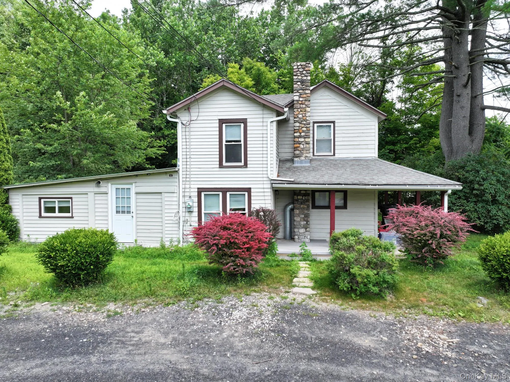 View of front of home featuring a chimney, a porch, and a shingled roof View of front of home featuring a chimney, a porch, and a shingled roof