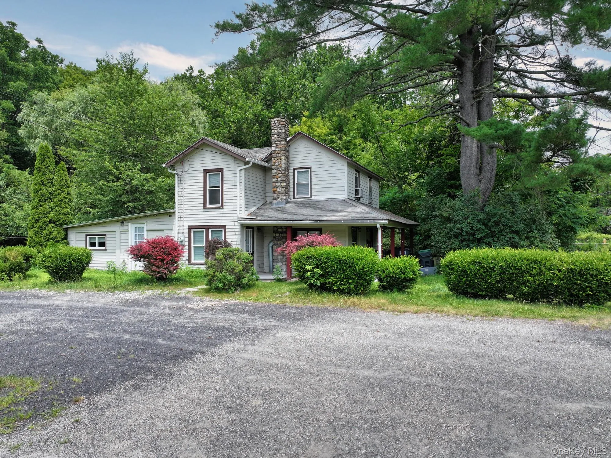 View of front of house with a chimney and a view of trees View of front of house with a chimney and a view of trees