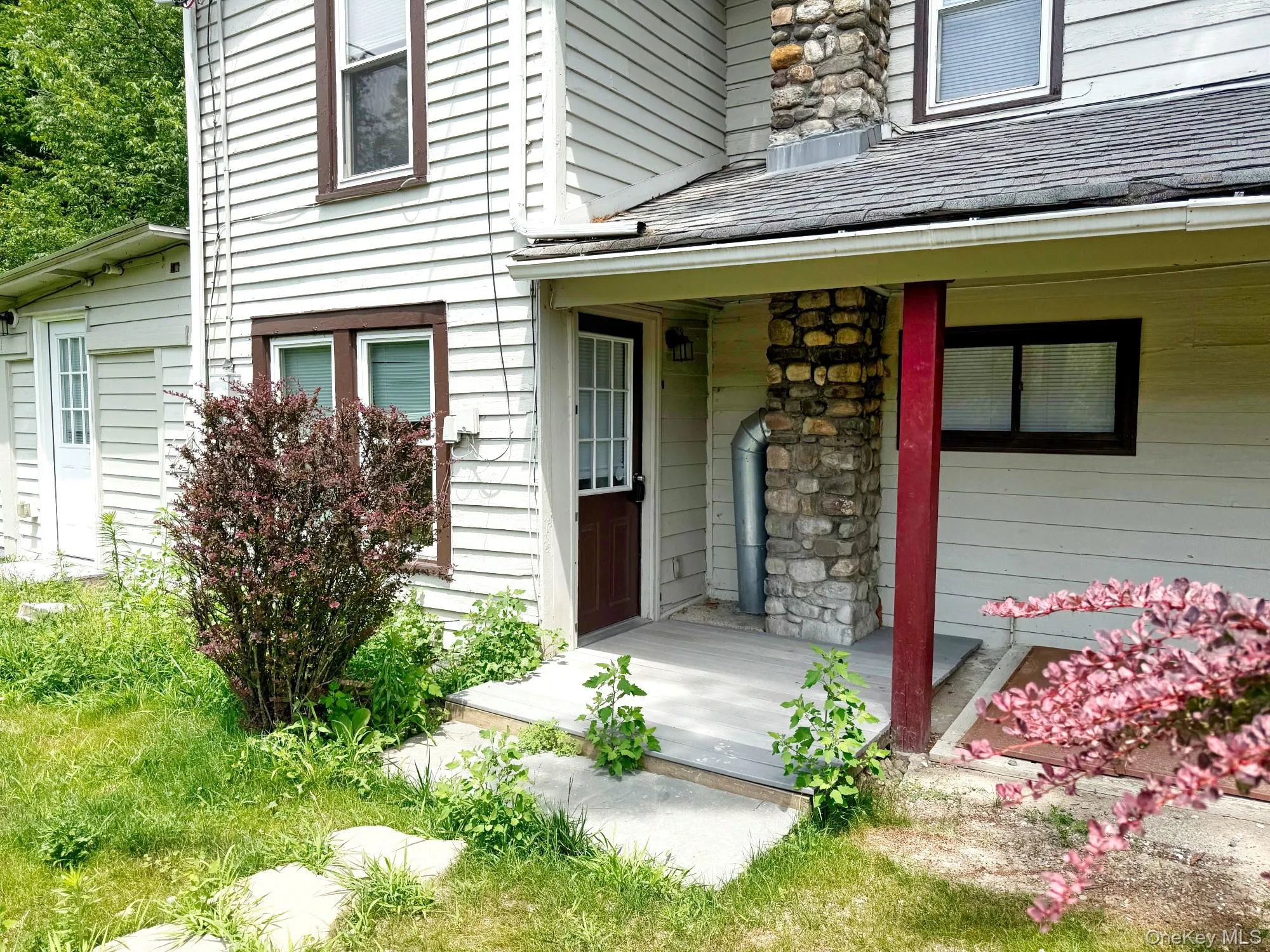 View of exterior entry featuring covered porch and stone siding View of exterior entry featuring covered porch and stone siding