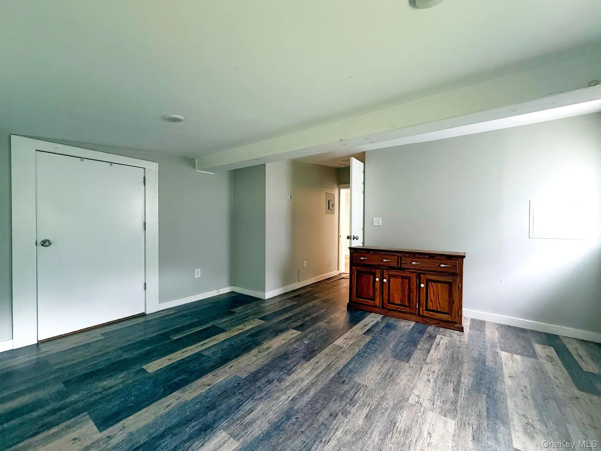 Unfurnished room with dark wood finished floors and baseboards Unfurnished room with dark wood finished floors and baseboards