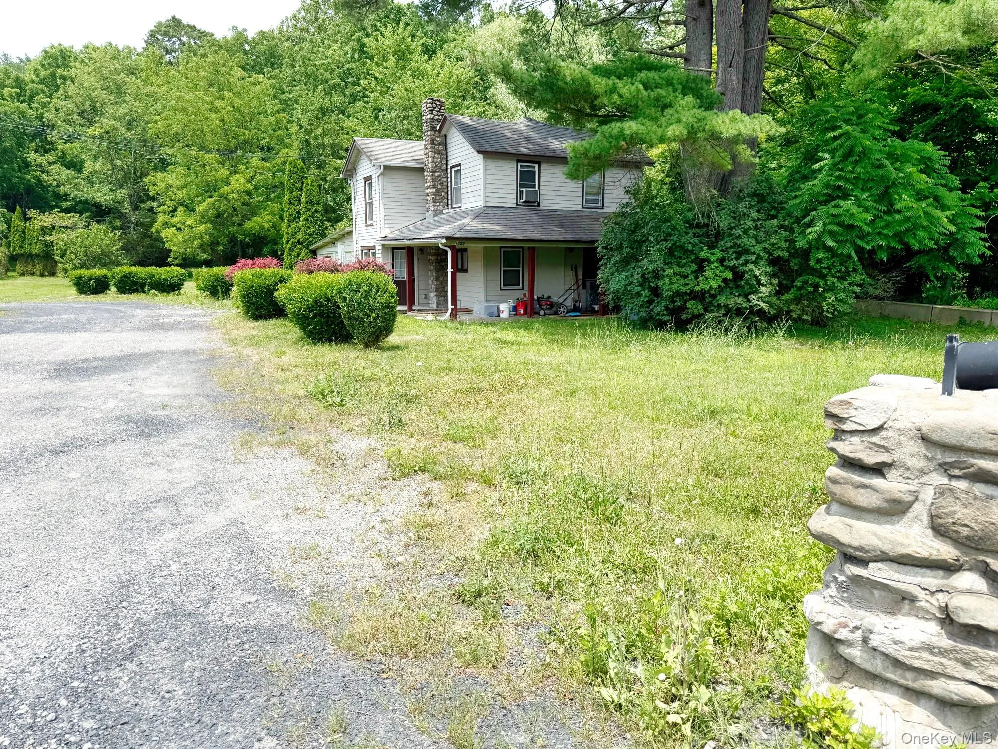 View of front of home featuring a chimney, roof with shingles, a porch, and driveway View of front of home featuring a chimney, roof with shingles, a porch, and driveway