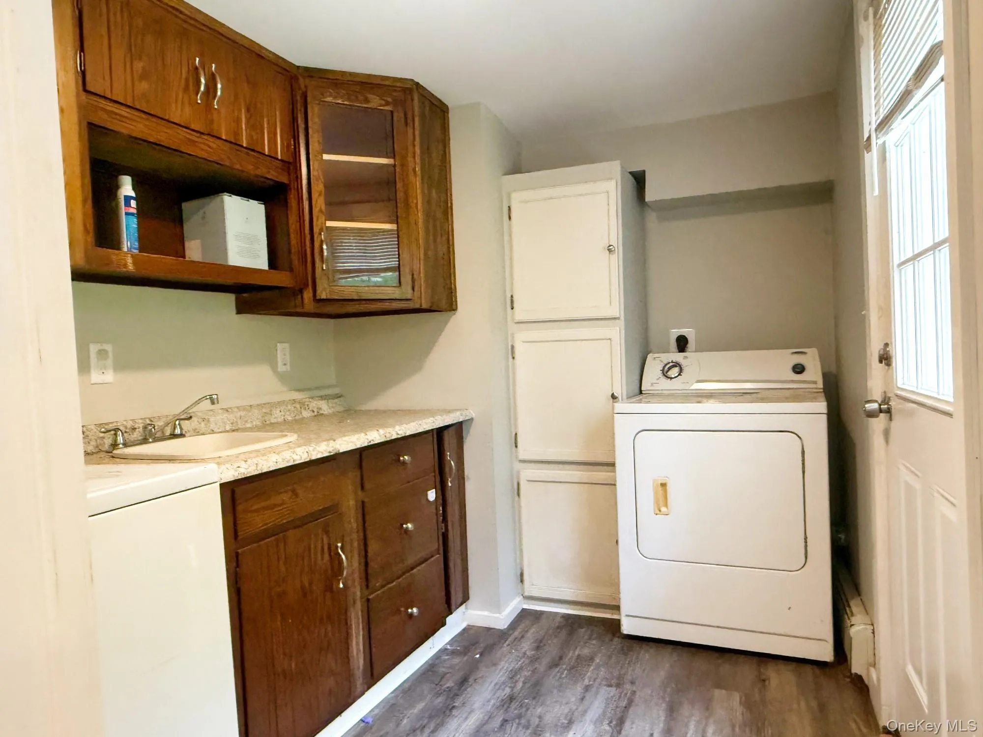 Laundry room with washer / clothes dryer, dark wood finished floors, and healthy amount of natural light Laundry room with washer / clothes dryer, dark wood finished floors, and healthy amount of natural light