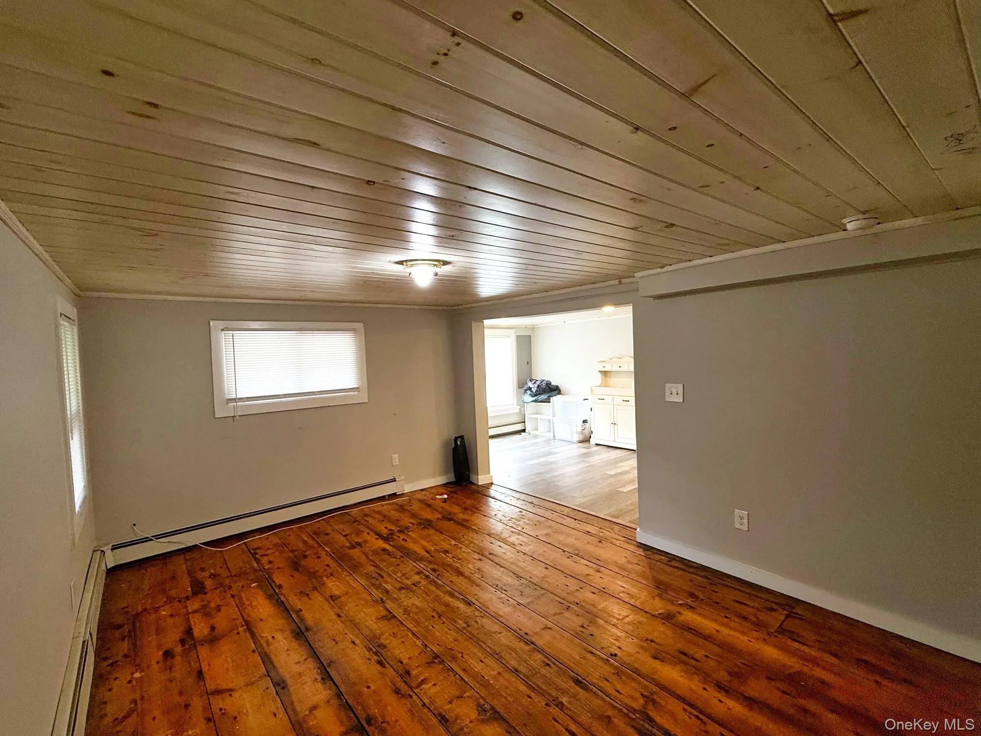 Spare room with wood ceiling, baseboard heating, hardwood / wood-style floors, and ornamental molding Spare room with wood ceiling, baseboard heating, hardwood / wood-style floors, and ornamental molding