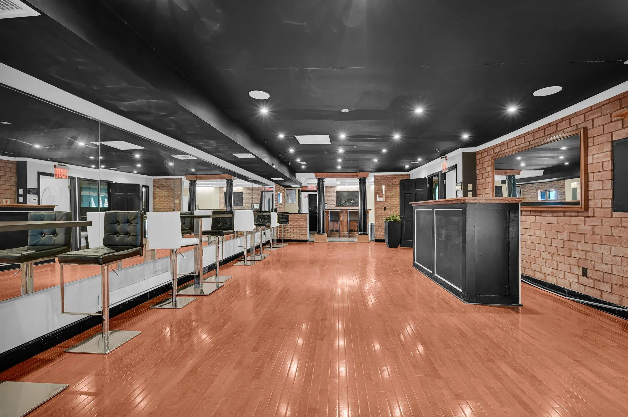 Kitchen with brick wall, dark cabinetry, light wood-style flooring, and a kitchen island Kitchen with brick wall, dark cabinetry, light wood-style flooring, and a kitchen island