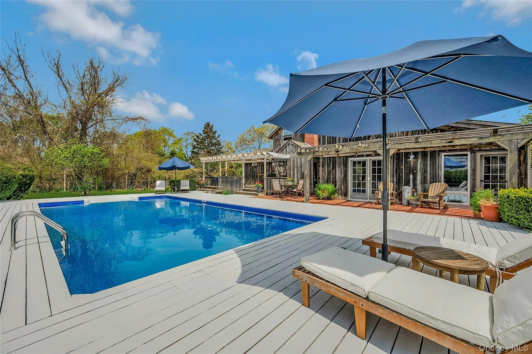 Swimming pool featuring a deck, a pergola, and french doors Swimming pool featuring a deck, a pergola, and french doors