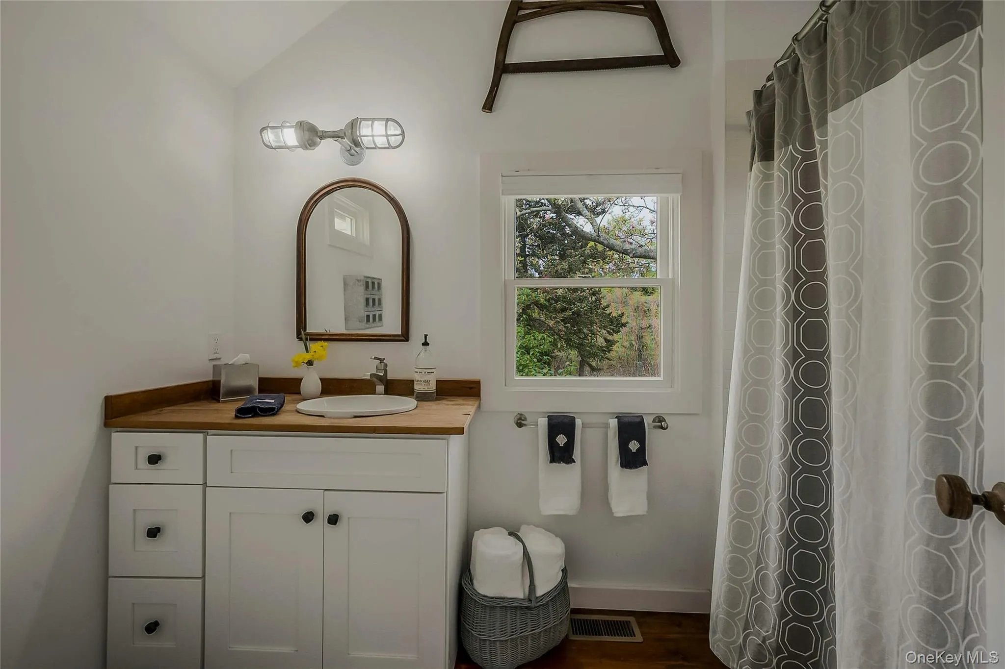 Full bath with vanity, vaulted ceiling, and wood finished floors Full bath with vanity, vaulted ceiling, and wood finished floors