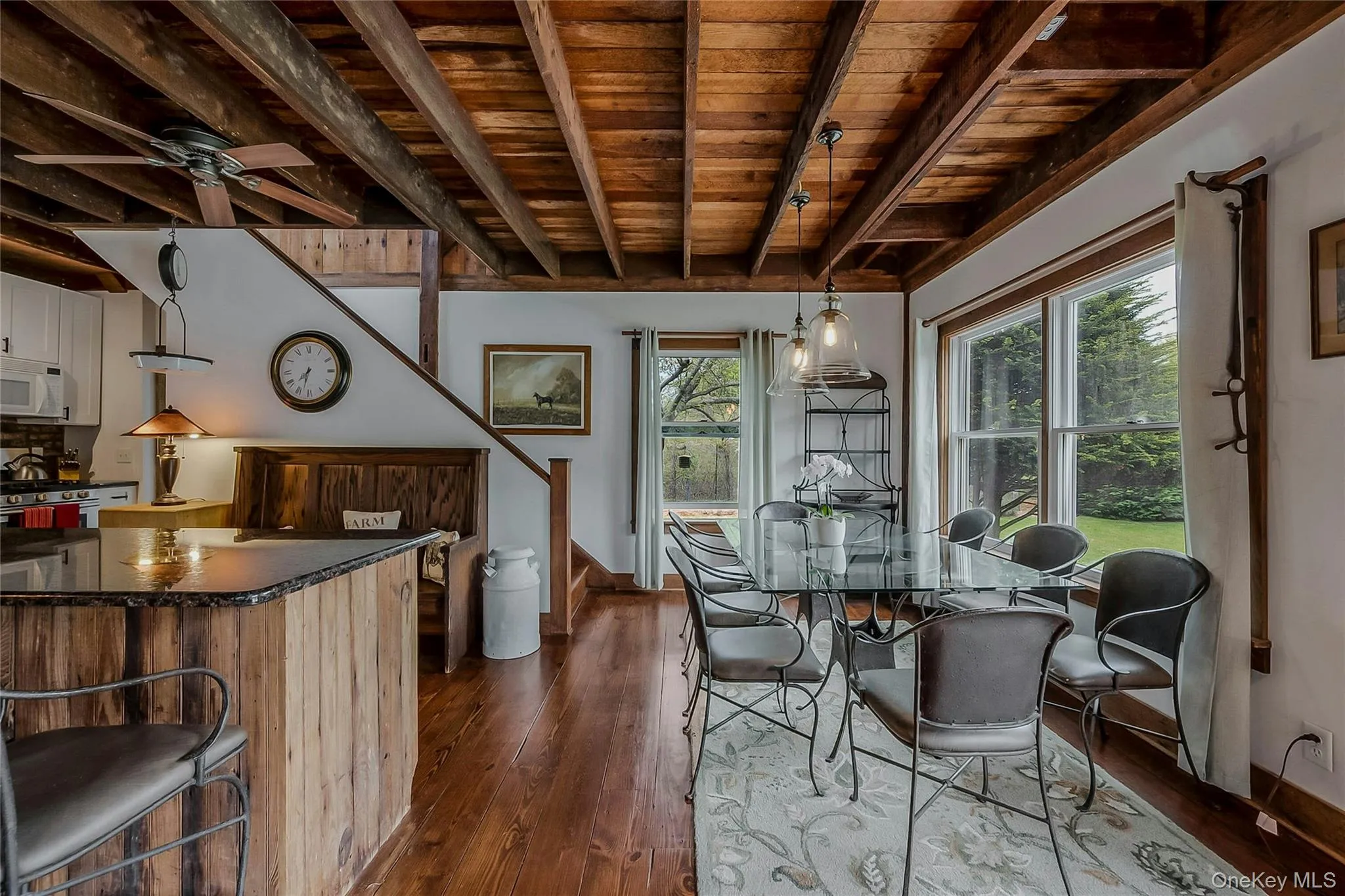 Dining area with wooden ceiling with exposed beams, baseboards, dark wood-type flooring, and ceiling fan Dining area with wooden ceiling with exposed beams, baseboards, dark wood-type flooring, and ceiling fan