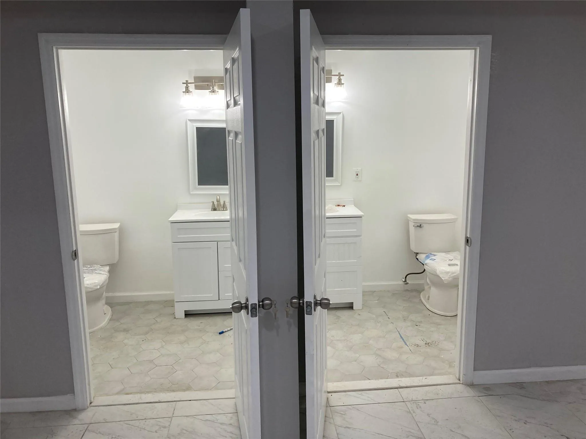 Bathroom featuring toilet, marble finish flooring, baseboards, and vanity Bathroom featuring toilet, marble finish flooring, baseboards, and vanity