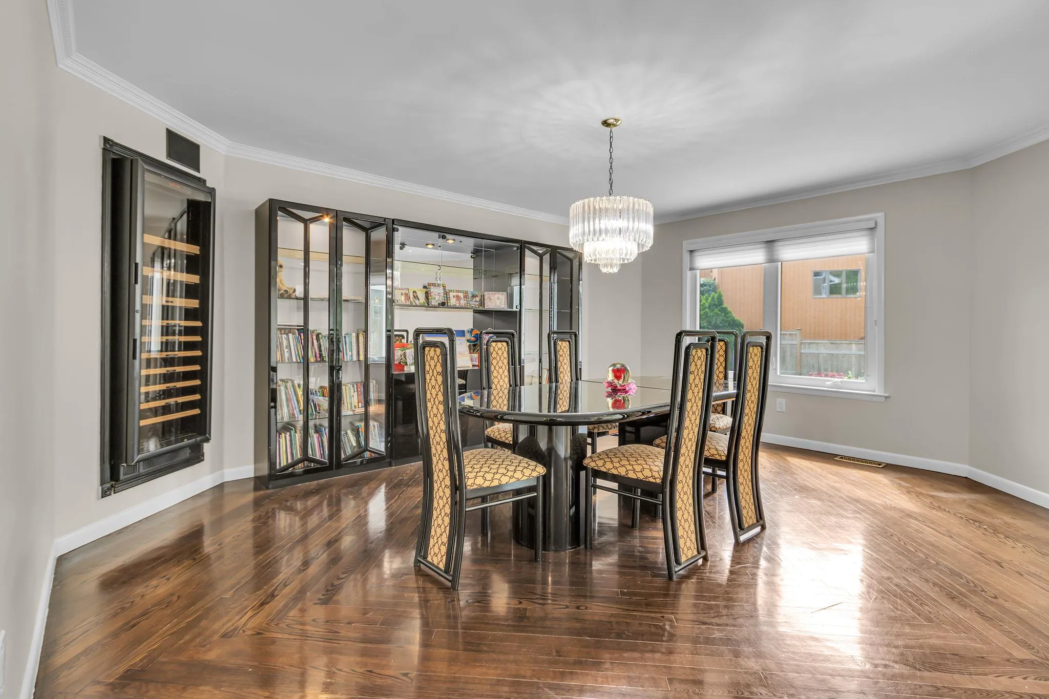 Dining room with wine cooler, a chandelier, baseboards, and ornamental molding Dining room with wine cooler, a chandelier, baseboards, and ornamental molding