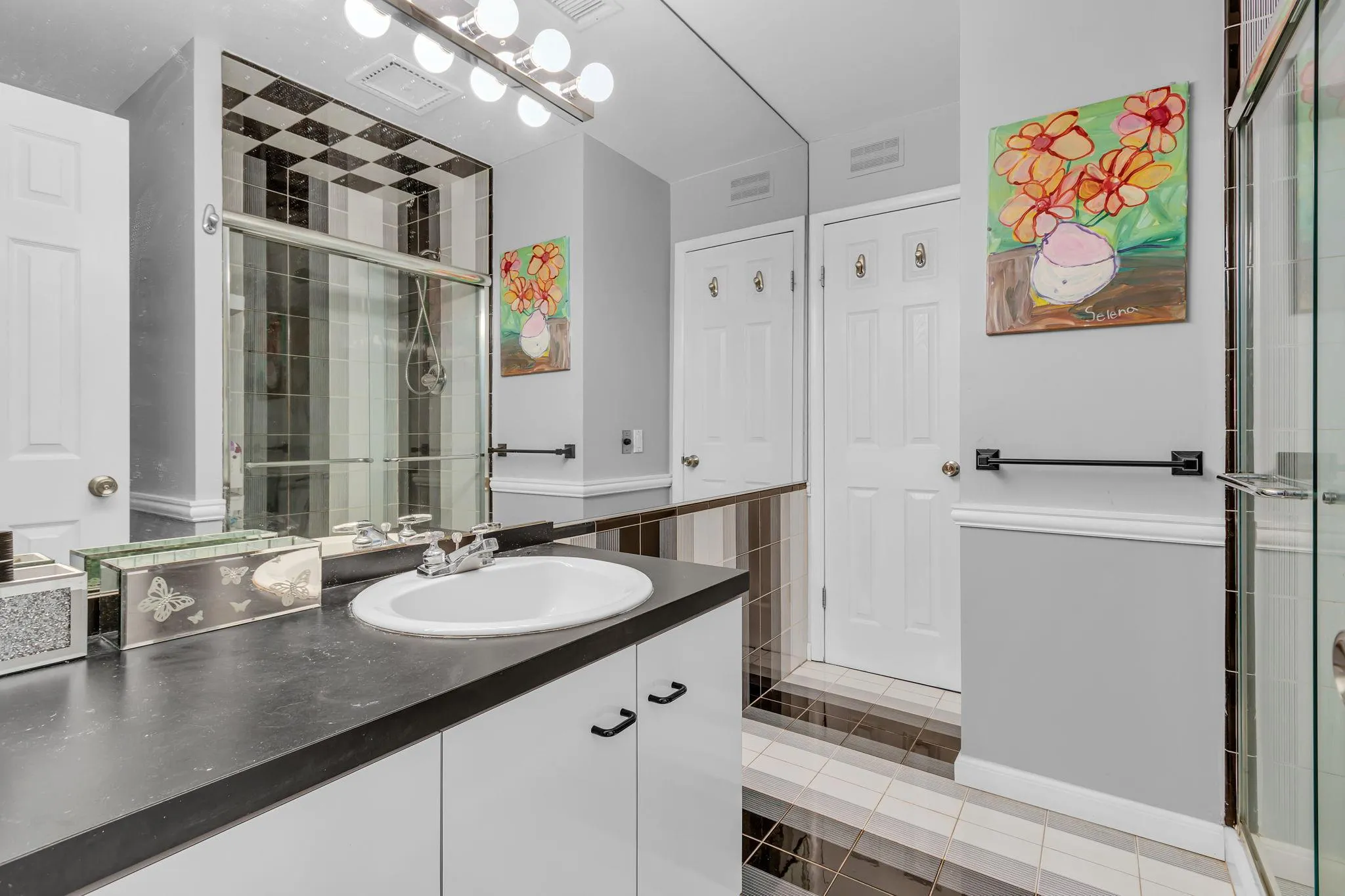 Full bath featuring vanity, a shower stall, and tile patterned flooring Full bath featuring vanity, a shower stall, and tile patterned flooring