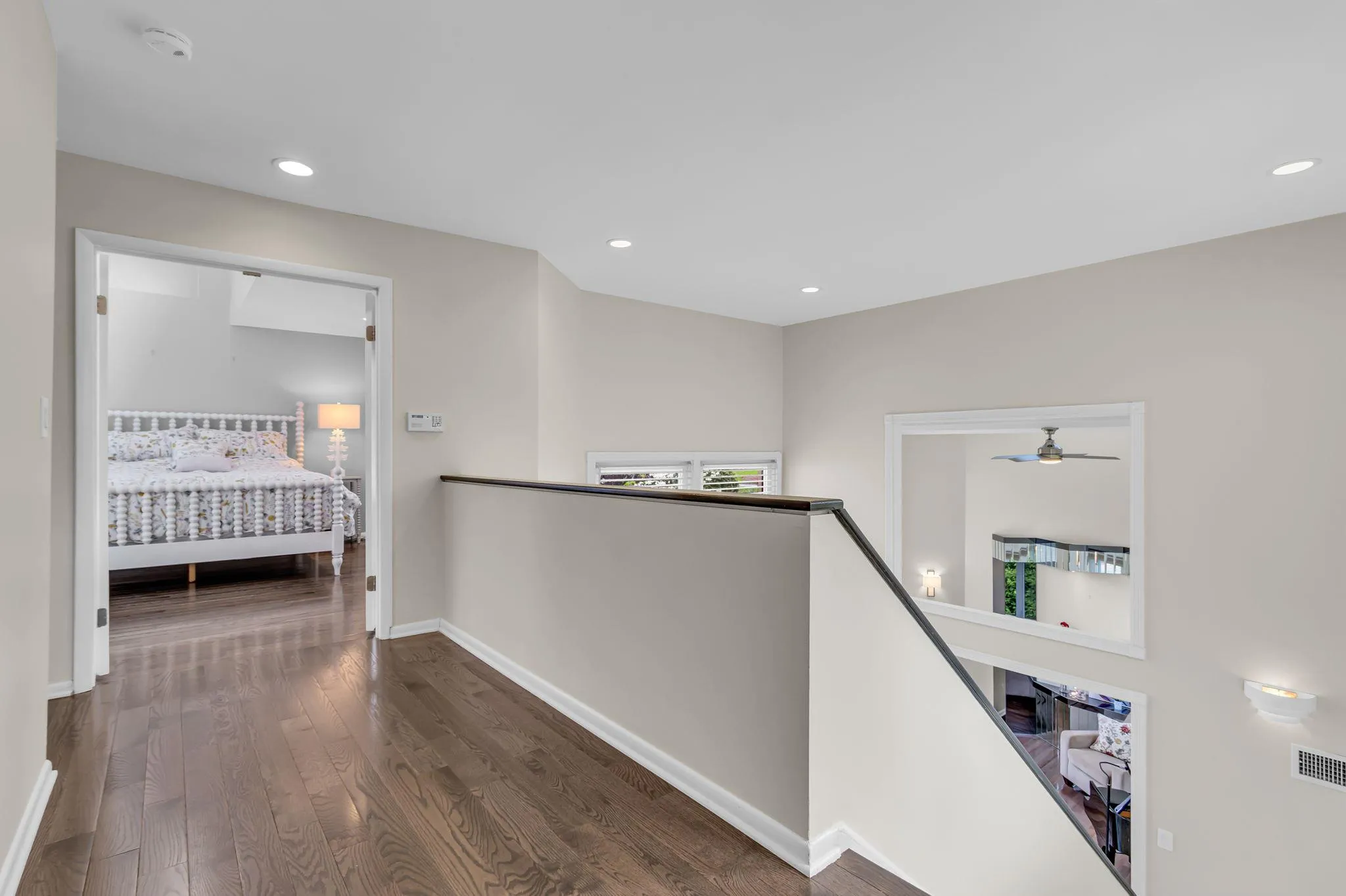 Corridor featuring wood finished floors, baseboards, recessed lighting, and an upstairs landing Corridor featuring wood finished floors, baseboards, recessed lighting, and an upstairs landing