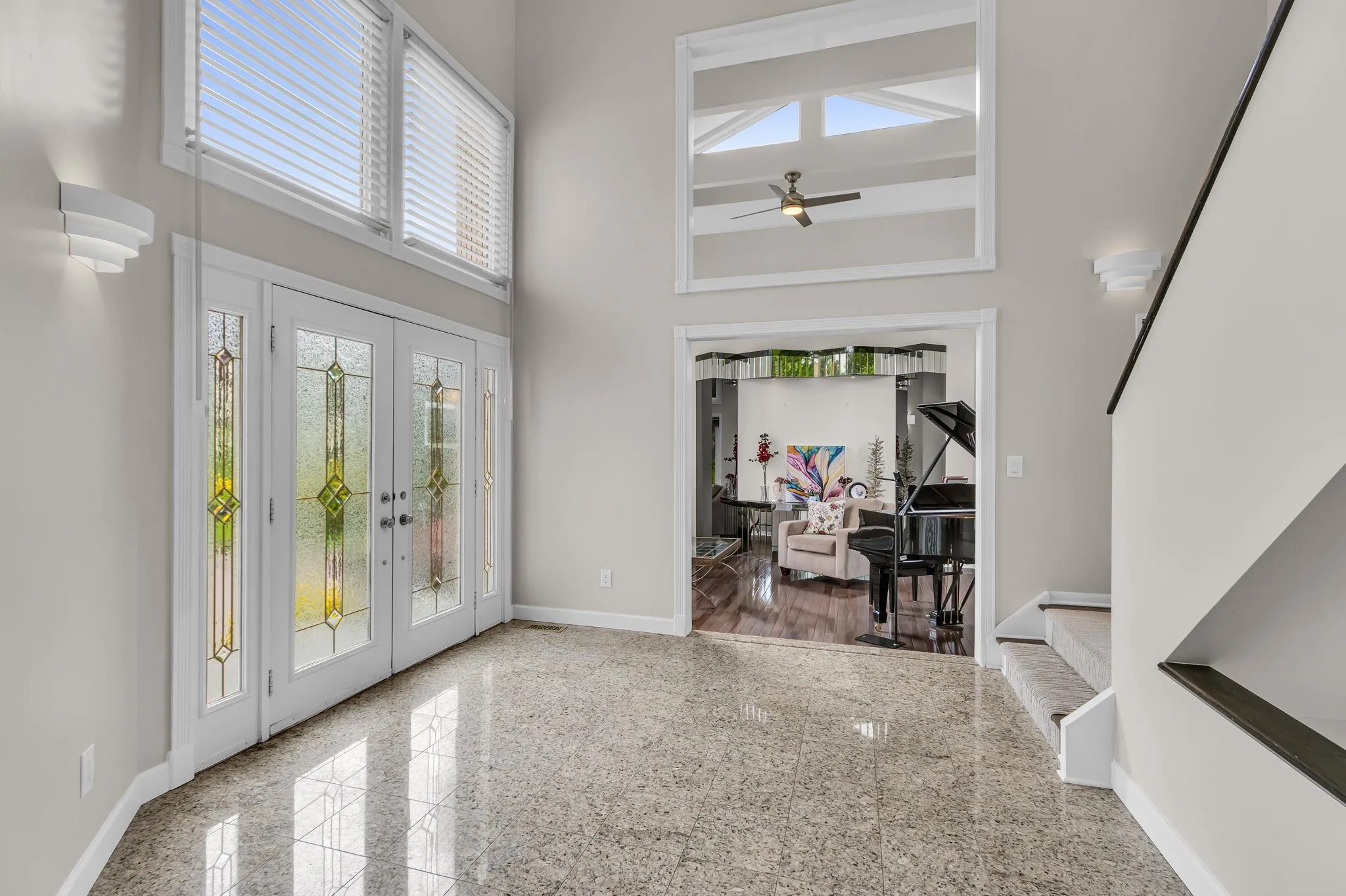Foyer with granite floors, a high ceiling, baseboards, french doors, and ceiling fan Foyer with granite floors, a high ceiling, baseboards, french doors, and ceiling fan