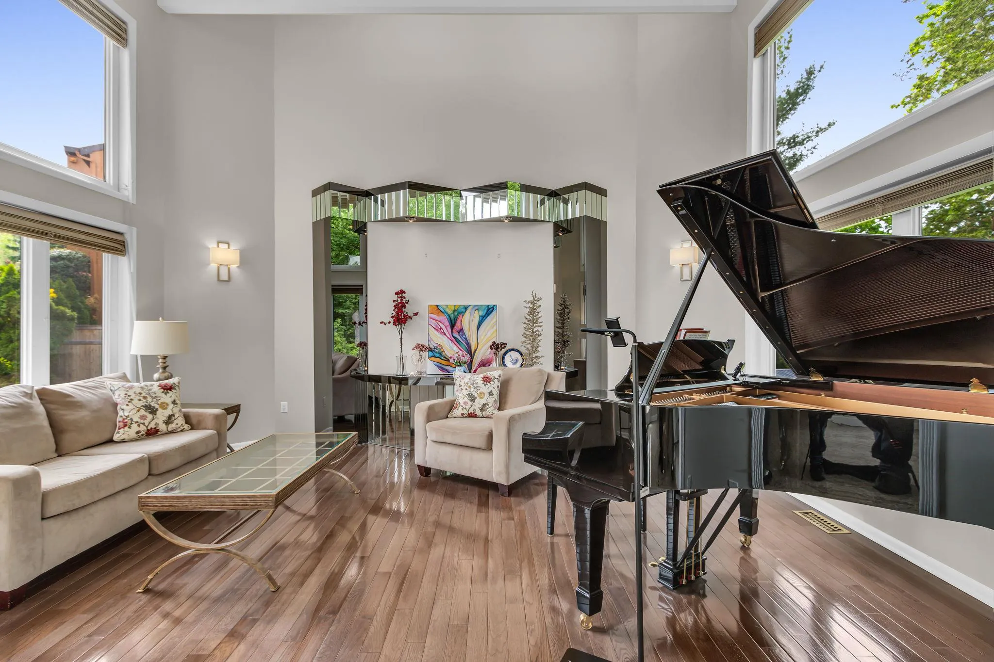 Living area with a high ceiling, healthy amount of natural light, and hardwood / wood-style flooring Living area with a high ceiling, healthy amount of natural light, and hardwood / wood-style flooring