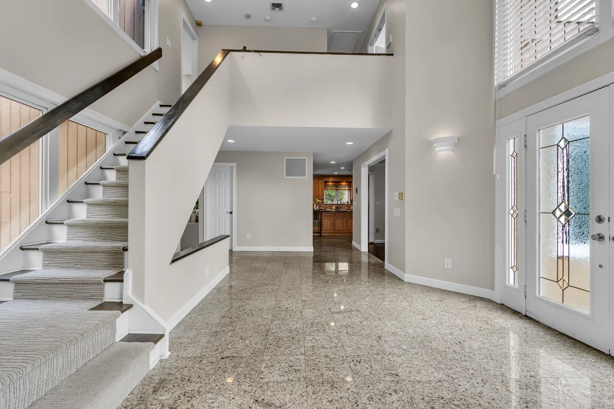 Foyer entrance featuring granite tiled floors, baseboards, a towering ceiling, stairway, and recessed lighting Foyer entrance featuring granite tiled floors, baseboards, a towering ceiling, stairway, and recessed lighting