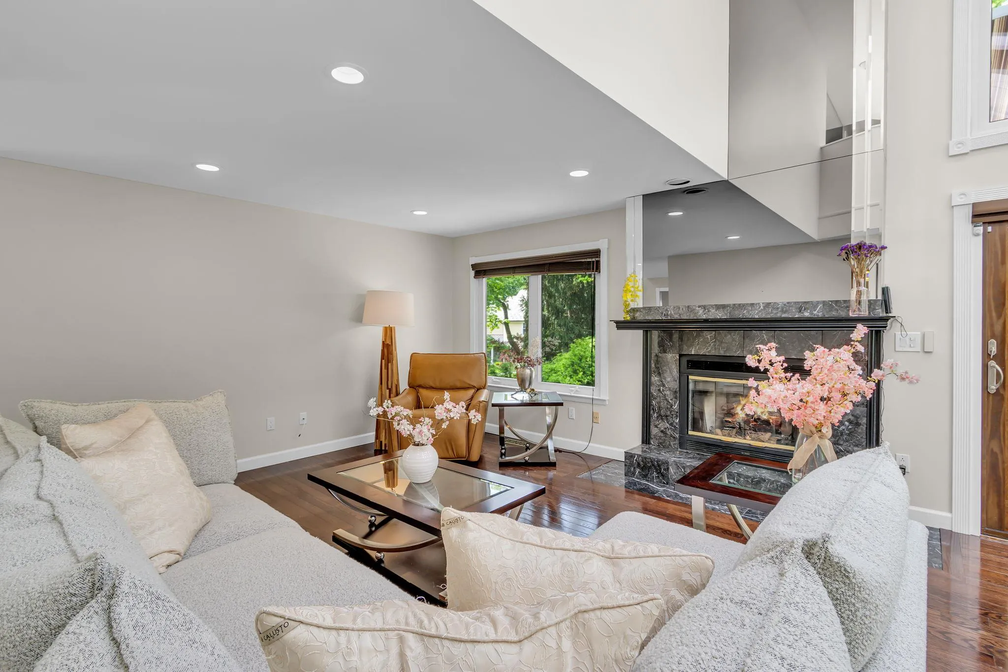 Living room featuring baseboards, wood finished floors, a tiled fireplace, and recessed lighting Living room featuring baseboards, wood finished floors, a tiled fireplace, and recessed lighting