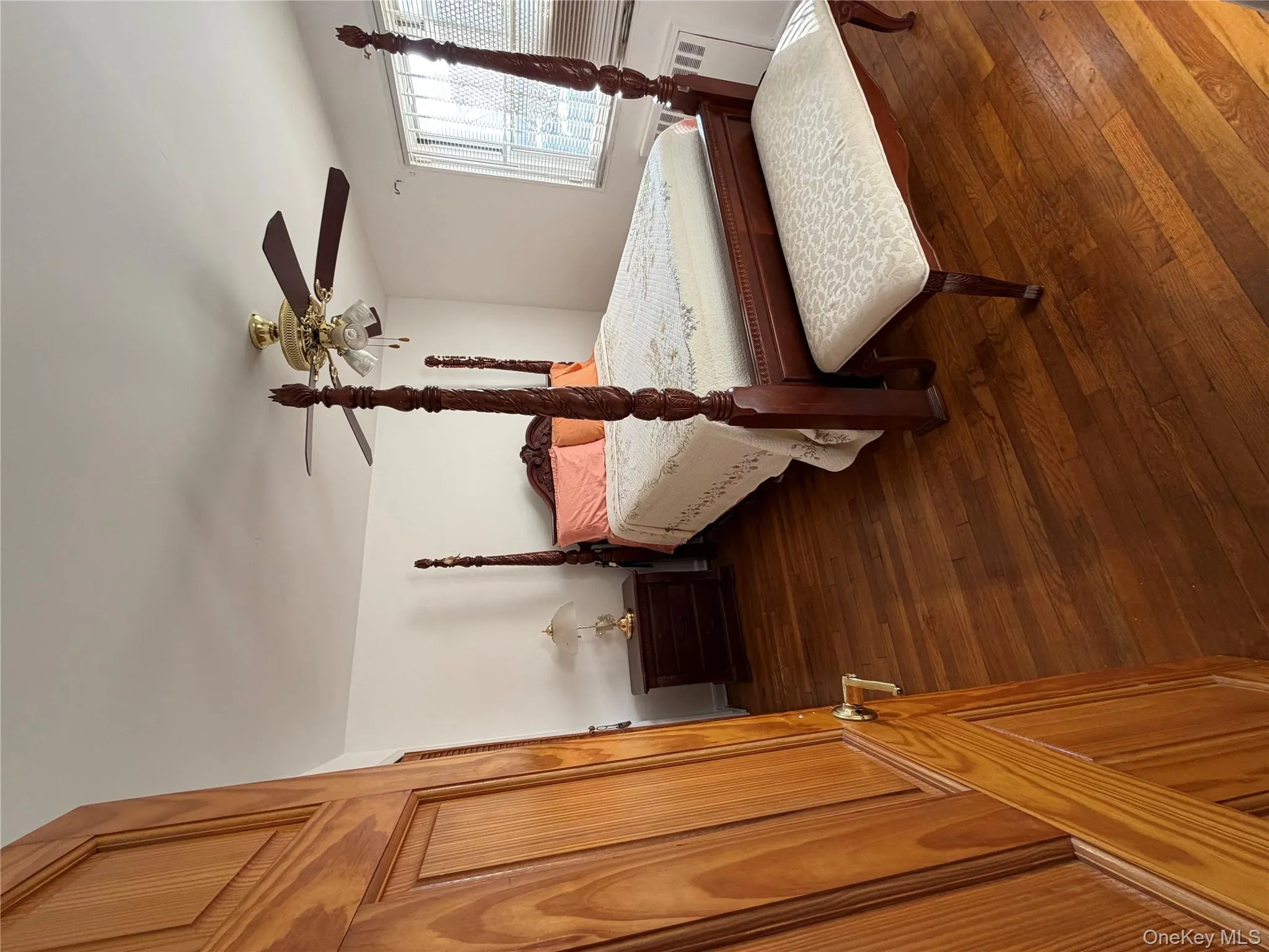 Bedroom with a ceiling fan, dark wood-style floors, and radiator heating unit Bedroom with a ceiling fan, dark wood-style floors, and radiator heating unit
