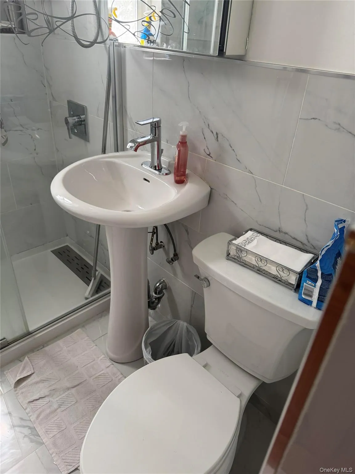 Bathroom with a stall shower, toilet, and tile walls Bathroom with a stall shower, toilet, and tile walls