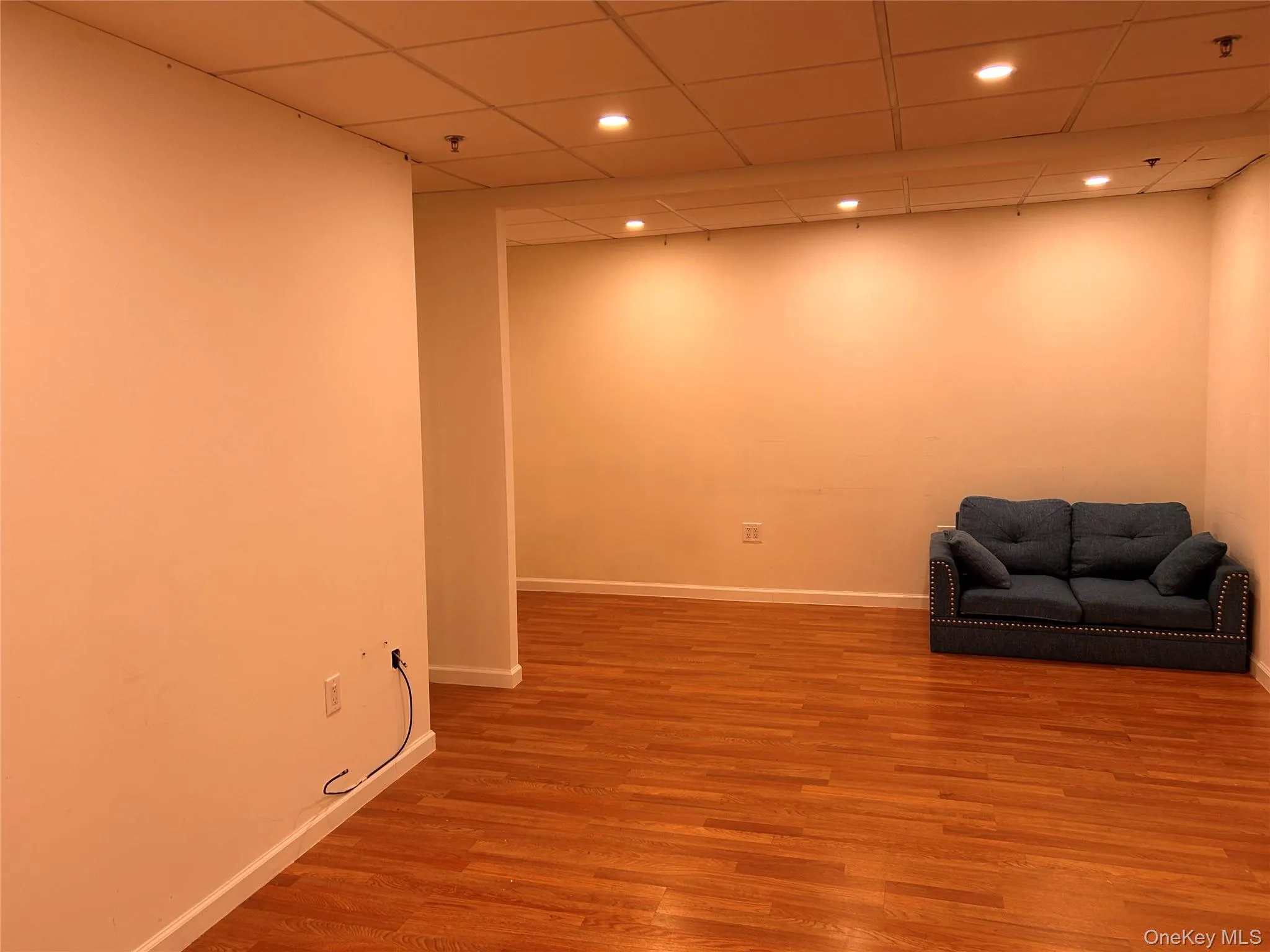 Unfurnished room featuring baseboards, wood finished floors, recessed lighting, and a drop ceiling Unfurnished room featuring baseboards, wood finished floors, recessed lighting, and a drop ceiling