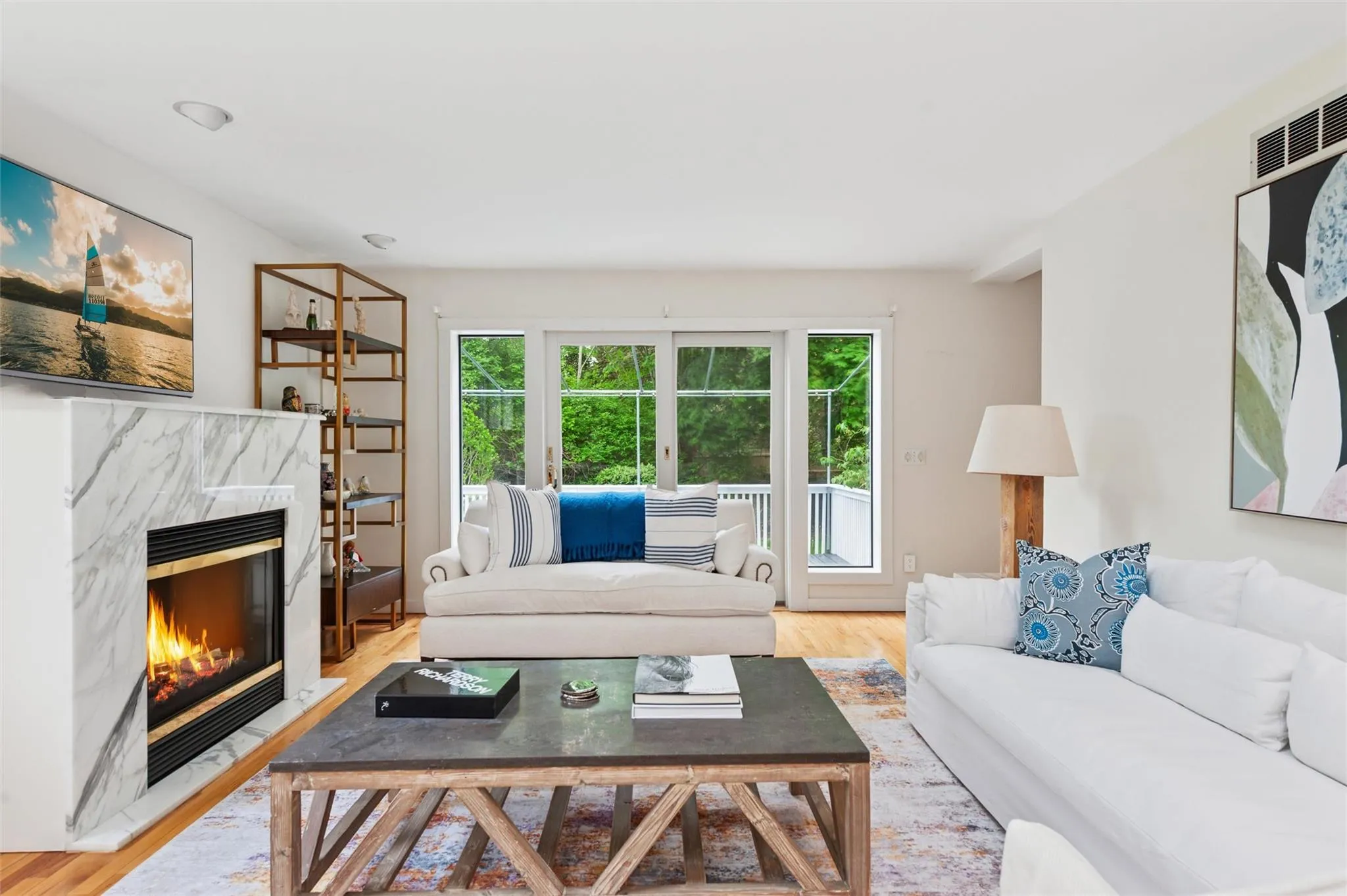 Living area featuring plenty of natural light, wood finished floors, and a fireplace Living area featuring plenty of natural light, wood finished floors, and a fireplace